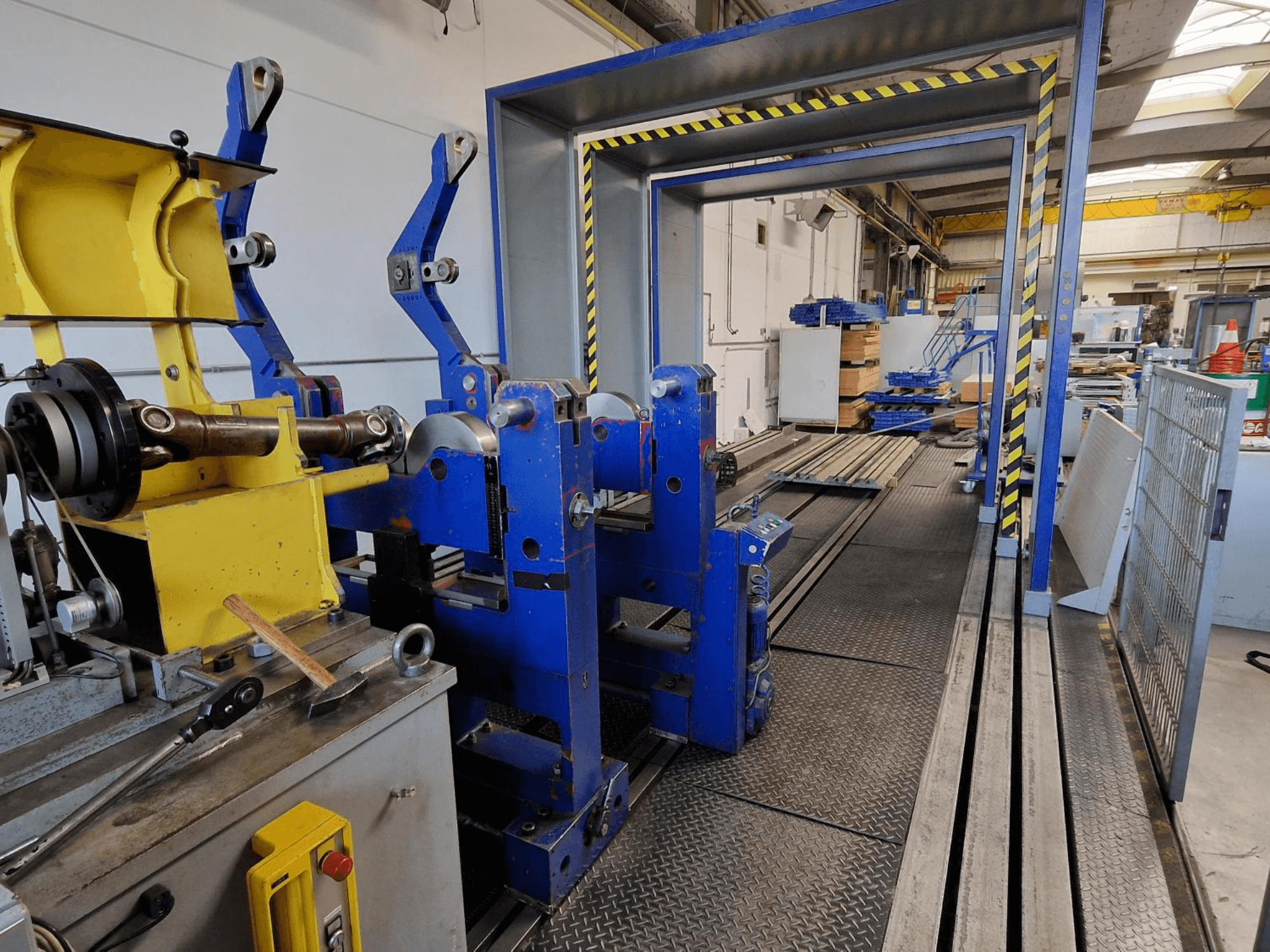 Machine-outil SCHENCK HM 70U BU, vue de profil montrant une structure bleue avec des composants jaunes et un panneau de commande dans un environnement industriel.
