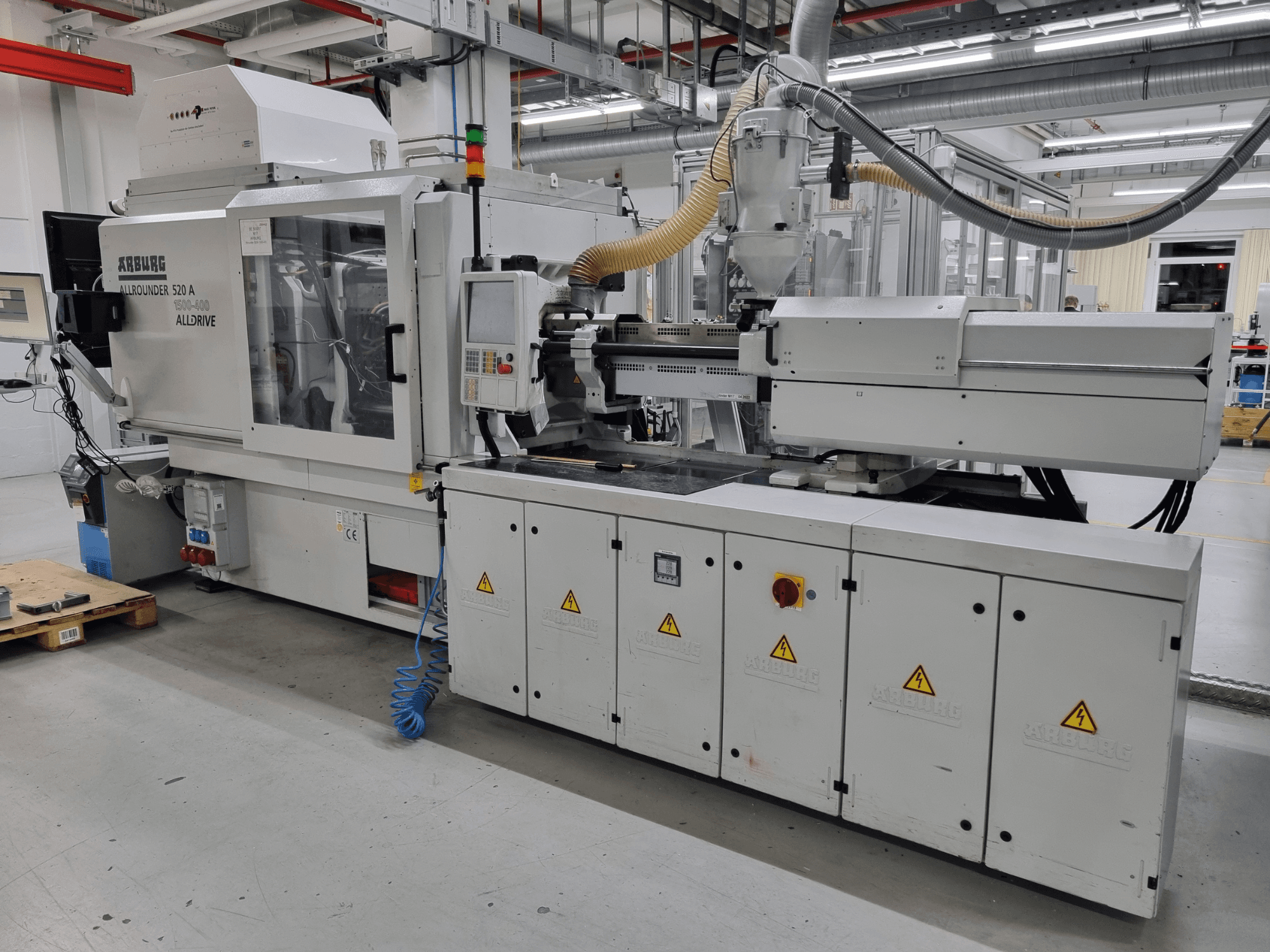 Machine de moulage par injection Arburg Allrounder 520 A, vue latérale, présentant le panneau de commande et les dispositifs de sécurité.