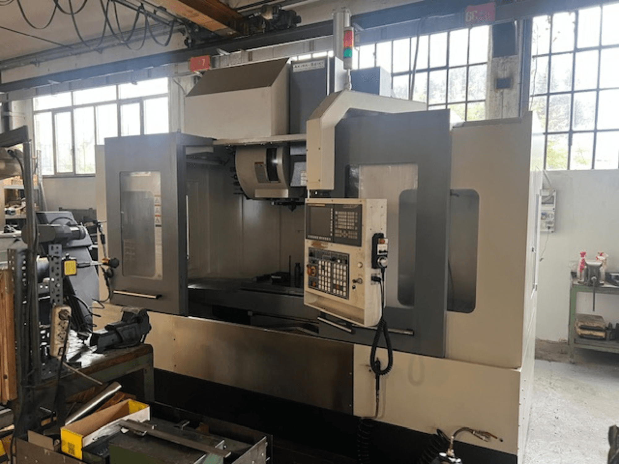 Fraiseuse CNC de haute technologie, vue de face, avec commandes numériques, indicateurs de sécurité de base et conception compacte.