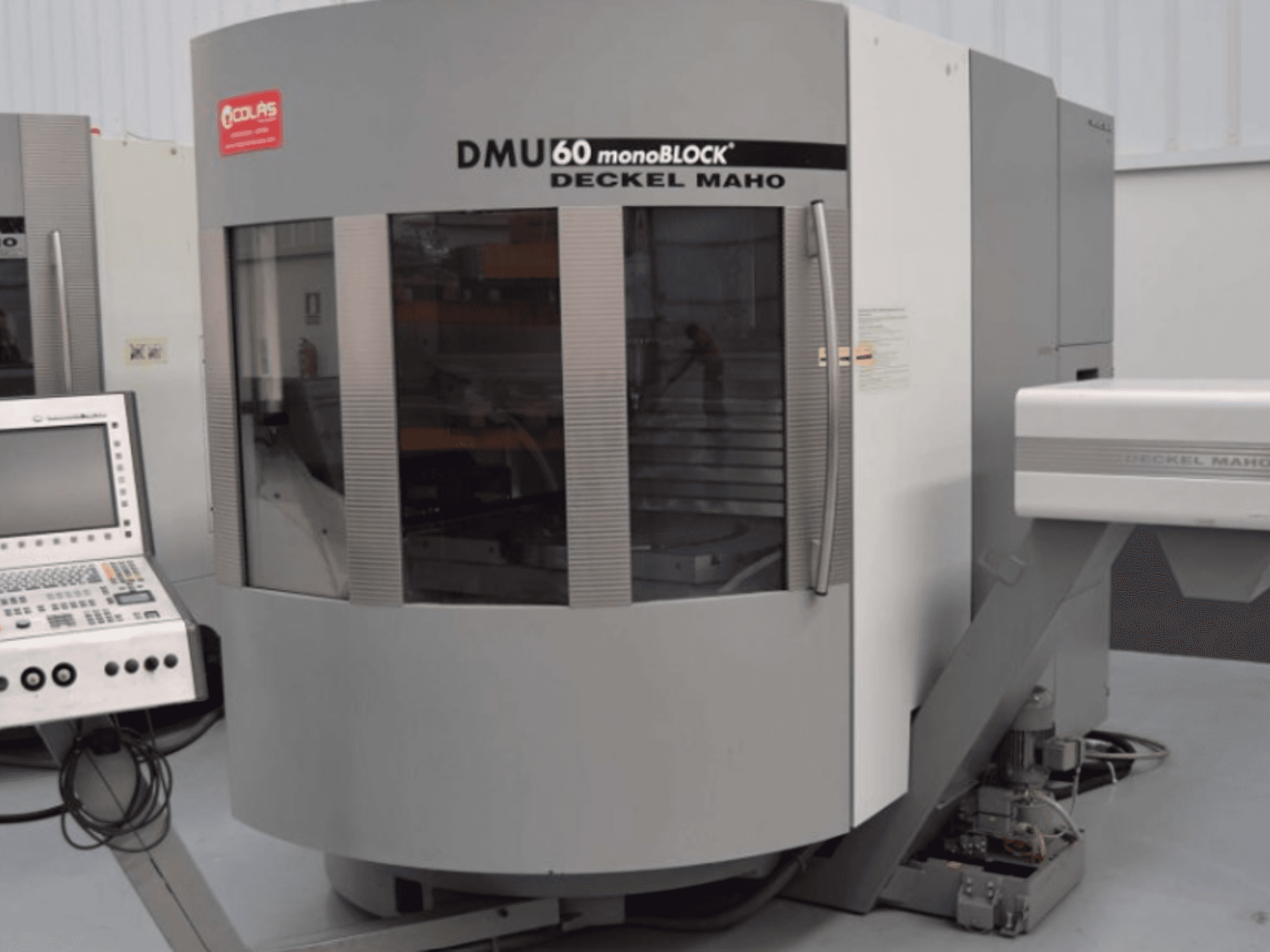 Centre d'usinage vertical monobloc DMG DMU60, vu de face, avec le panneau de commande visible à gauche.