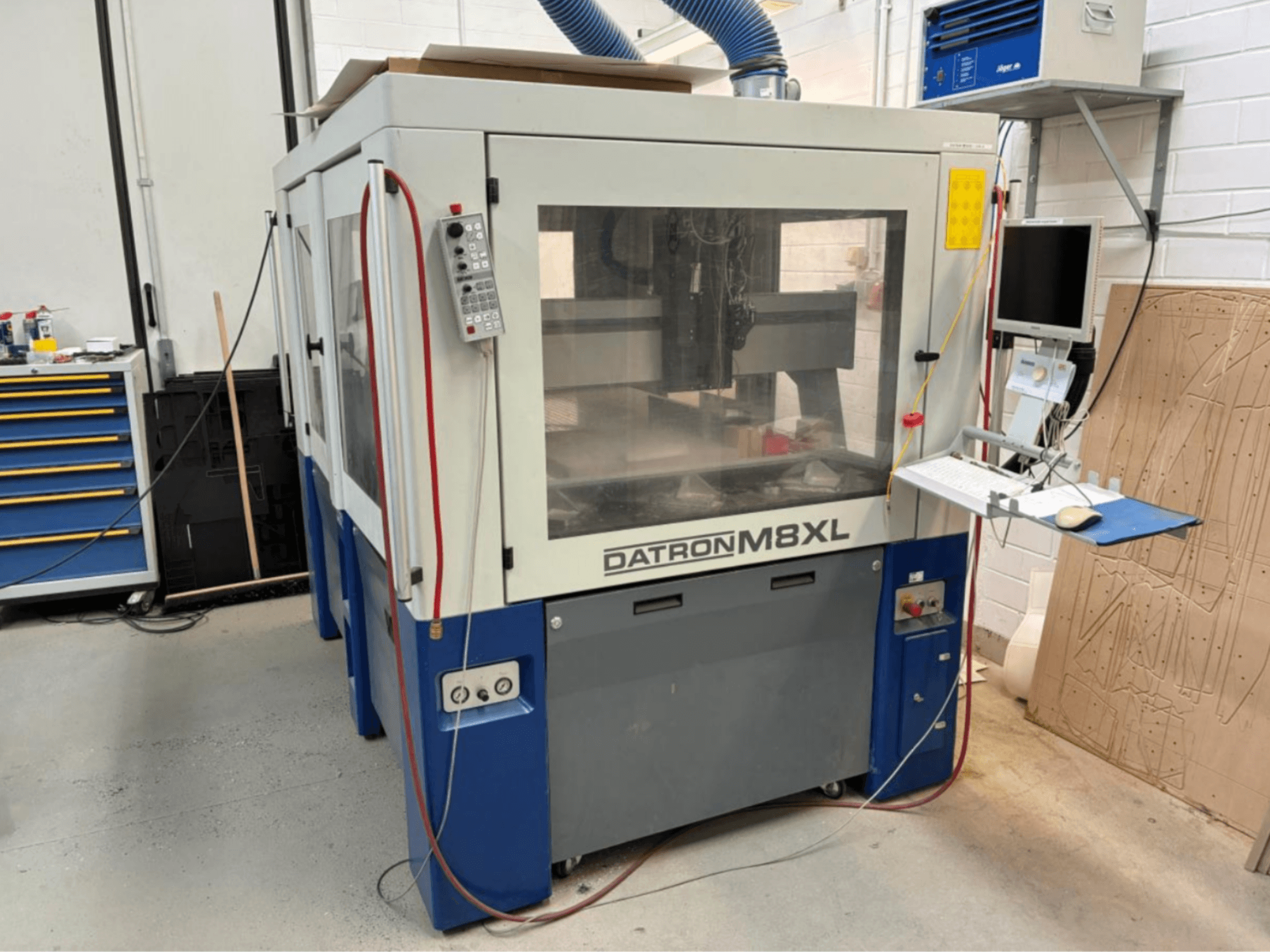 Machine CNC DATRON M8XL dans un atelier, vue de face avec le panneau de commande et le moniteur montés à côté.