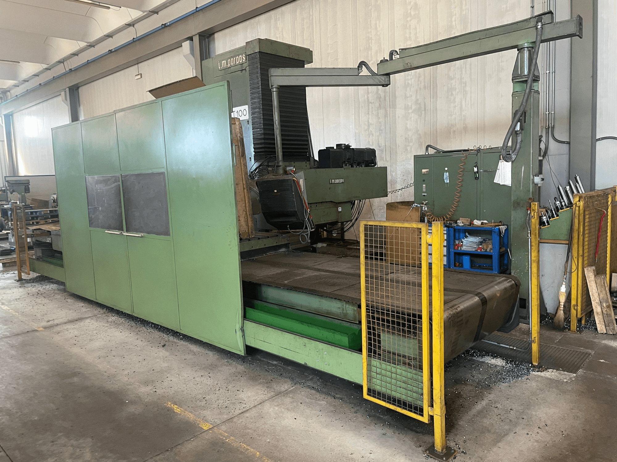 Grande fraiseuse industrielle verte avec barrières de sécurité, vue de face, avec étiquette de modèle "l.m. parpas" et commandes visibles.