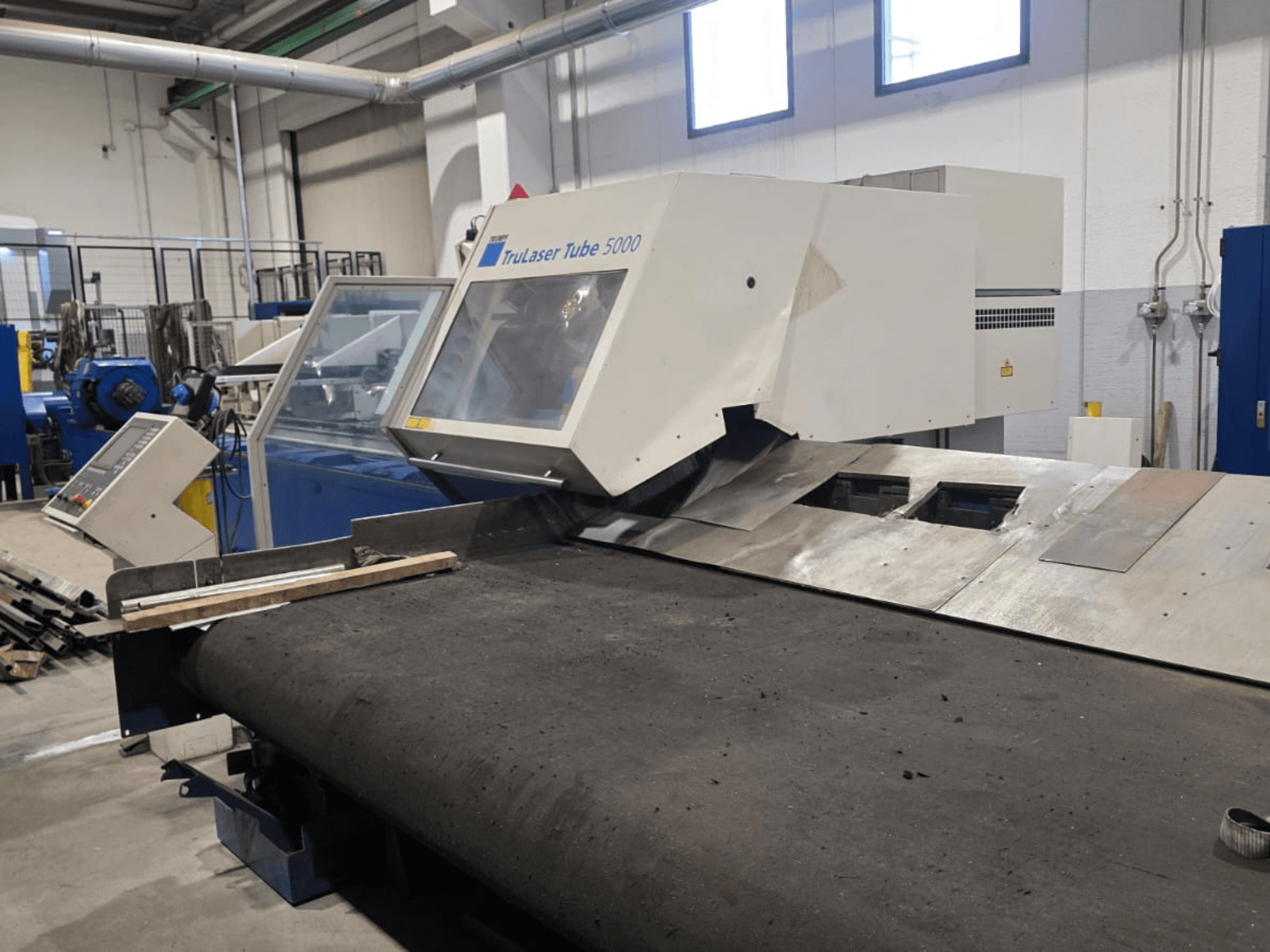 Machine de découpe de tubes TRUMPF LASERTUBE 5000, vue de face, montrant la zone de découpe et le panneau de commande.
