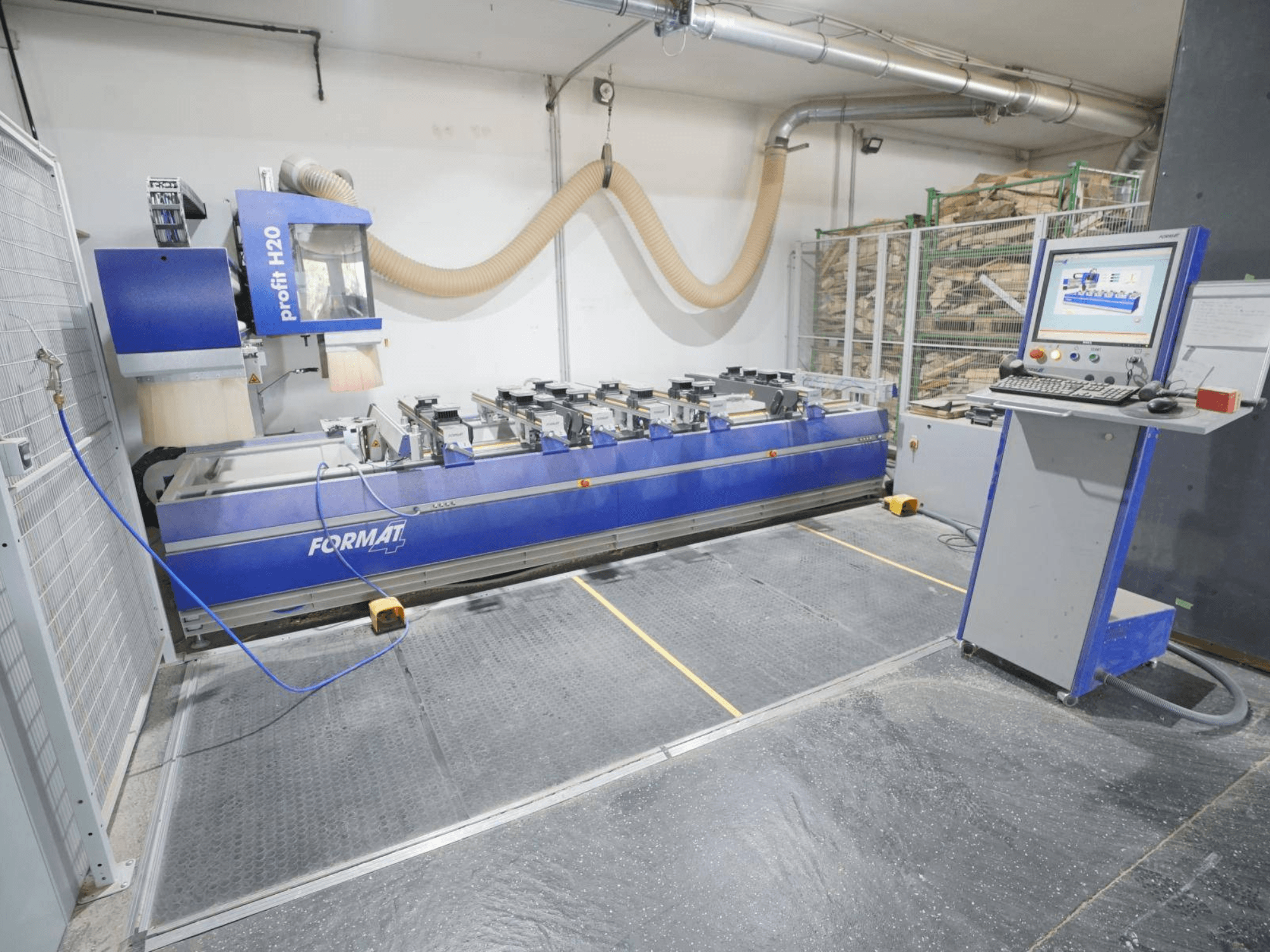 Centre d'usinage CNC du bois FORMAT4 PROFIT H20, vue de face avec le panneau de commande et les outils de coupe visibles dans un environnement industriel.