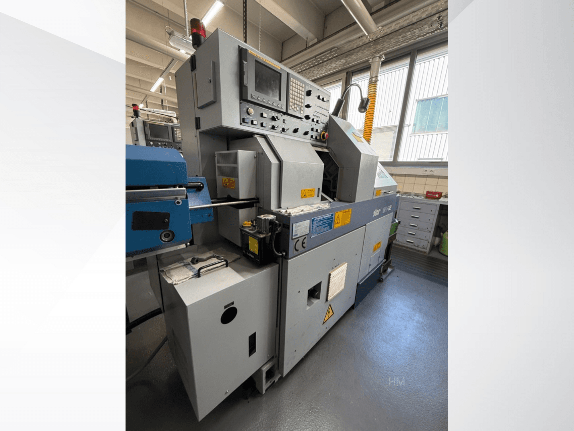 Vue avant de la machine lithec 3231, montrant le panneau de commande, le moteur et la section d'alimentation bleue dans un environnement industriel bien éclairé.