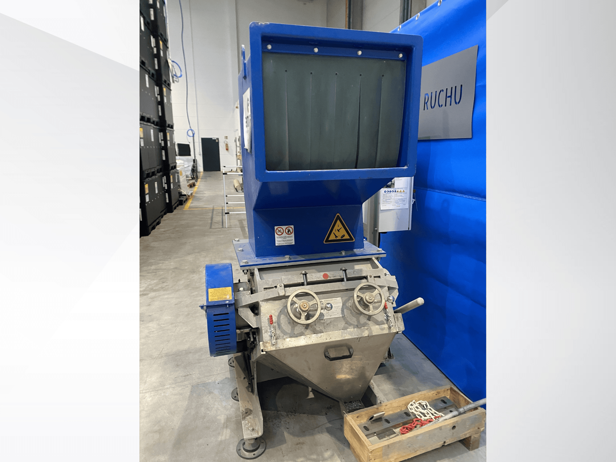 Vue de face de la machine de transformation des matières plastiques AMIS GSE 300/600, avec sa trémie bleue, ses boutons de commande et ses étiquettes d'avertissement.