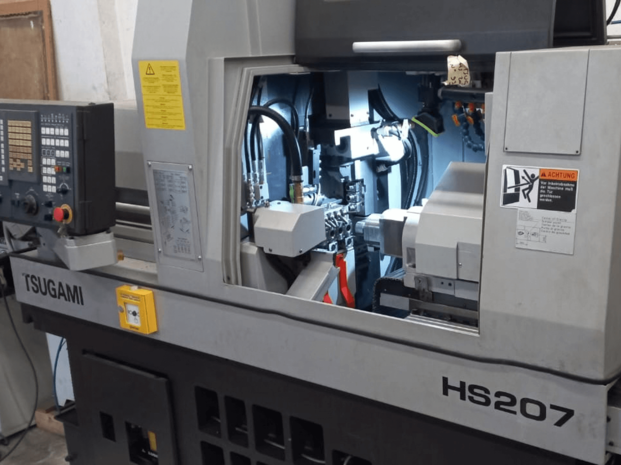Tour de type suisse TSUGAMI HS207, vue de face montrant le panneau de commande et les composants internes.