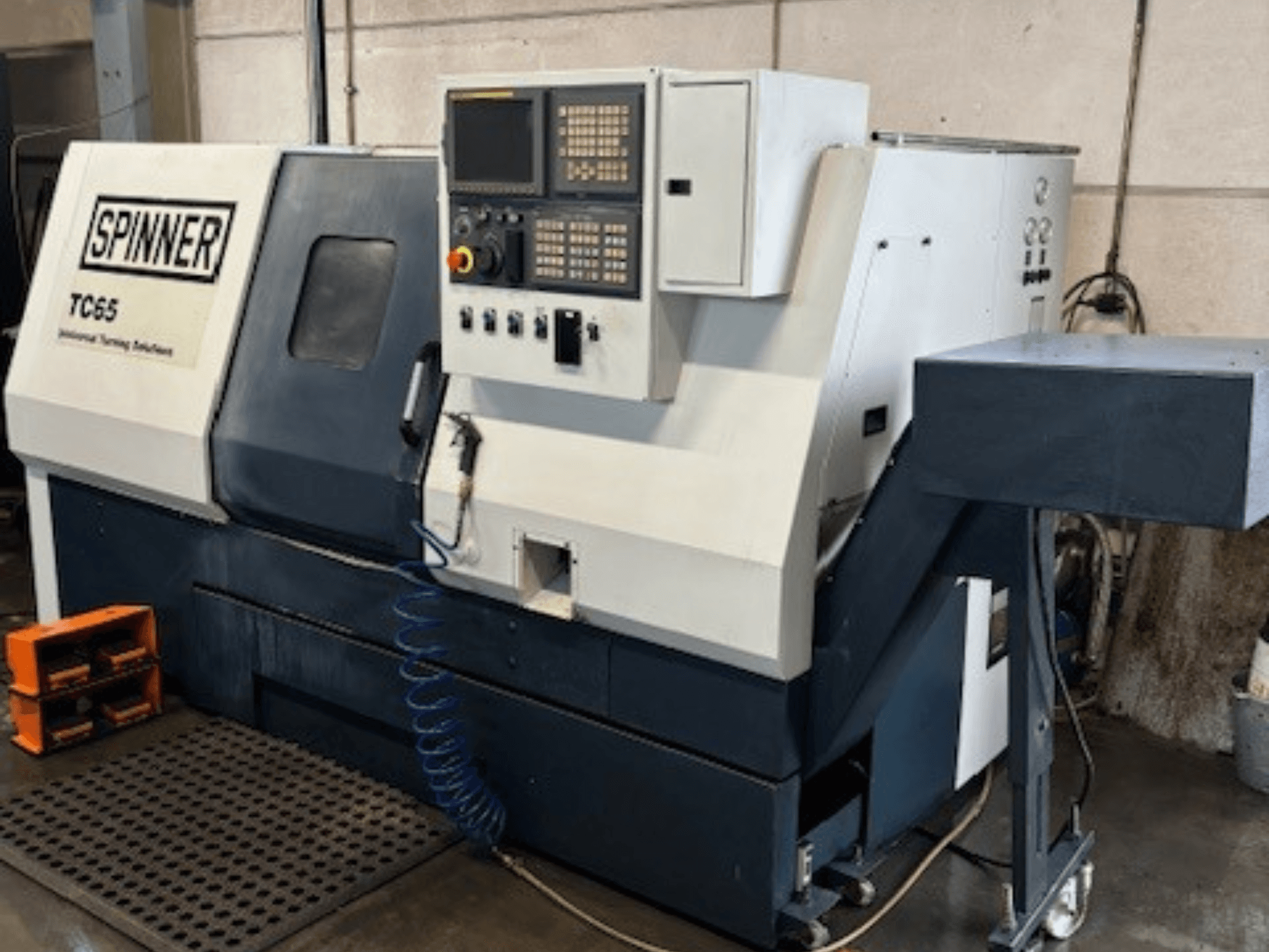 Tour industriel Spinner TC65, vue de face, avec panneau de commande, conduite d'air comprimé et zone de stockage des outils.
