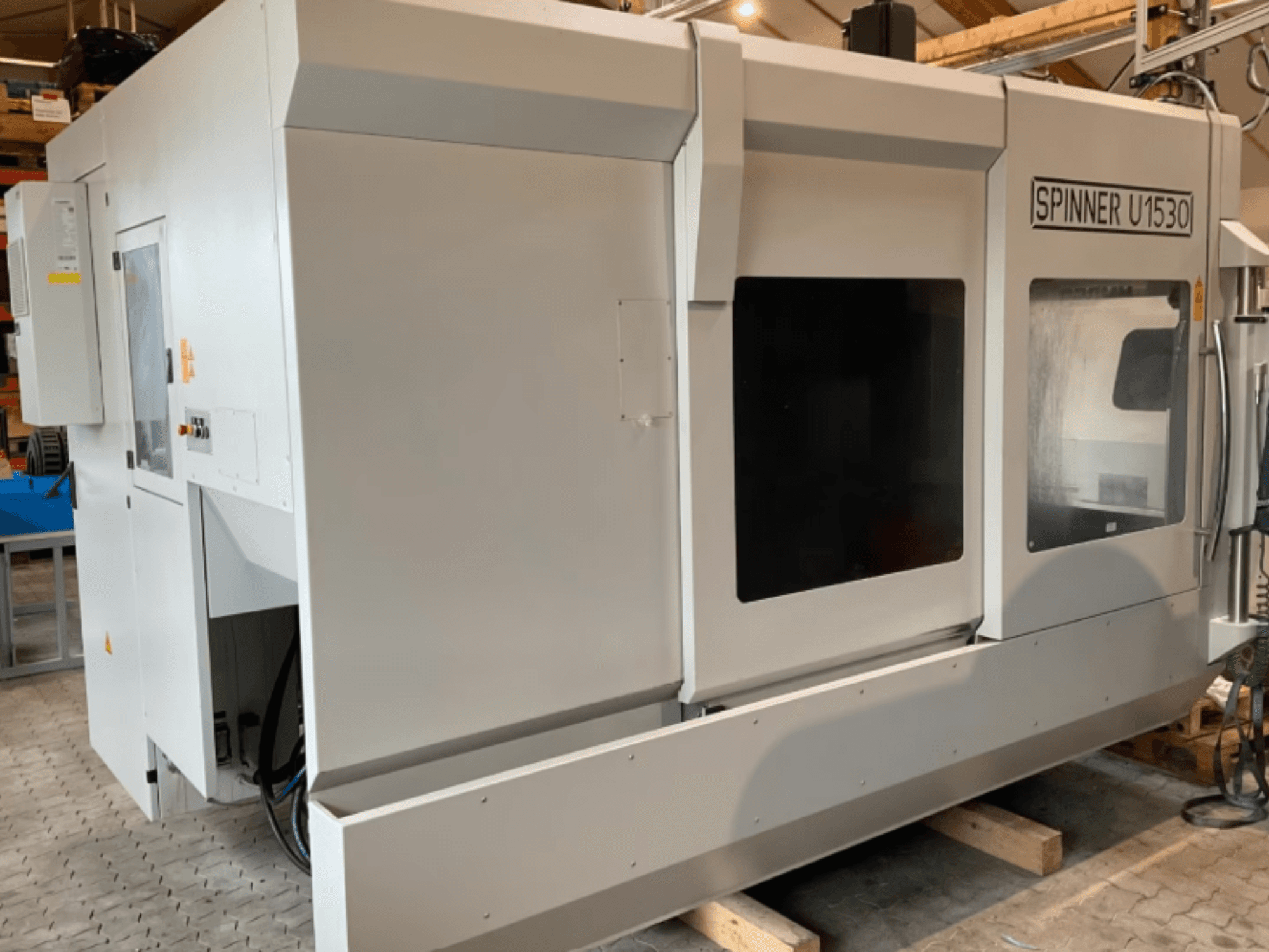 Centre d'usinage vertical SPINNER U5-1530 vu de profil, doté d'une grande zone de travail et d'un panneau de commande.