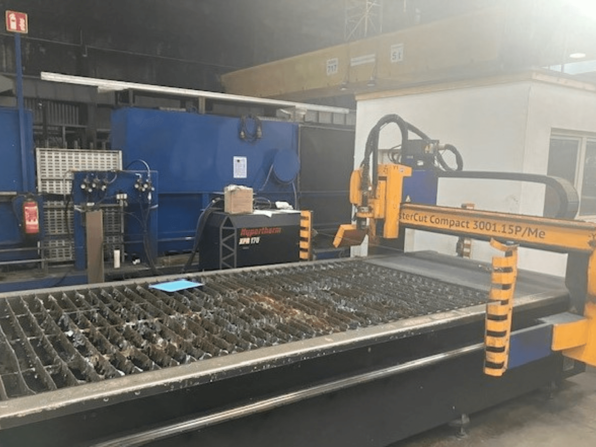 Machine de coupage plasma Hypertherm MasterCut Compact 3001.15P/Me en vue latérale, montrant la table de coupe et le panneau de commande.