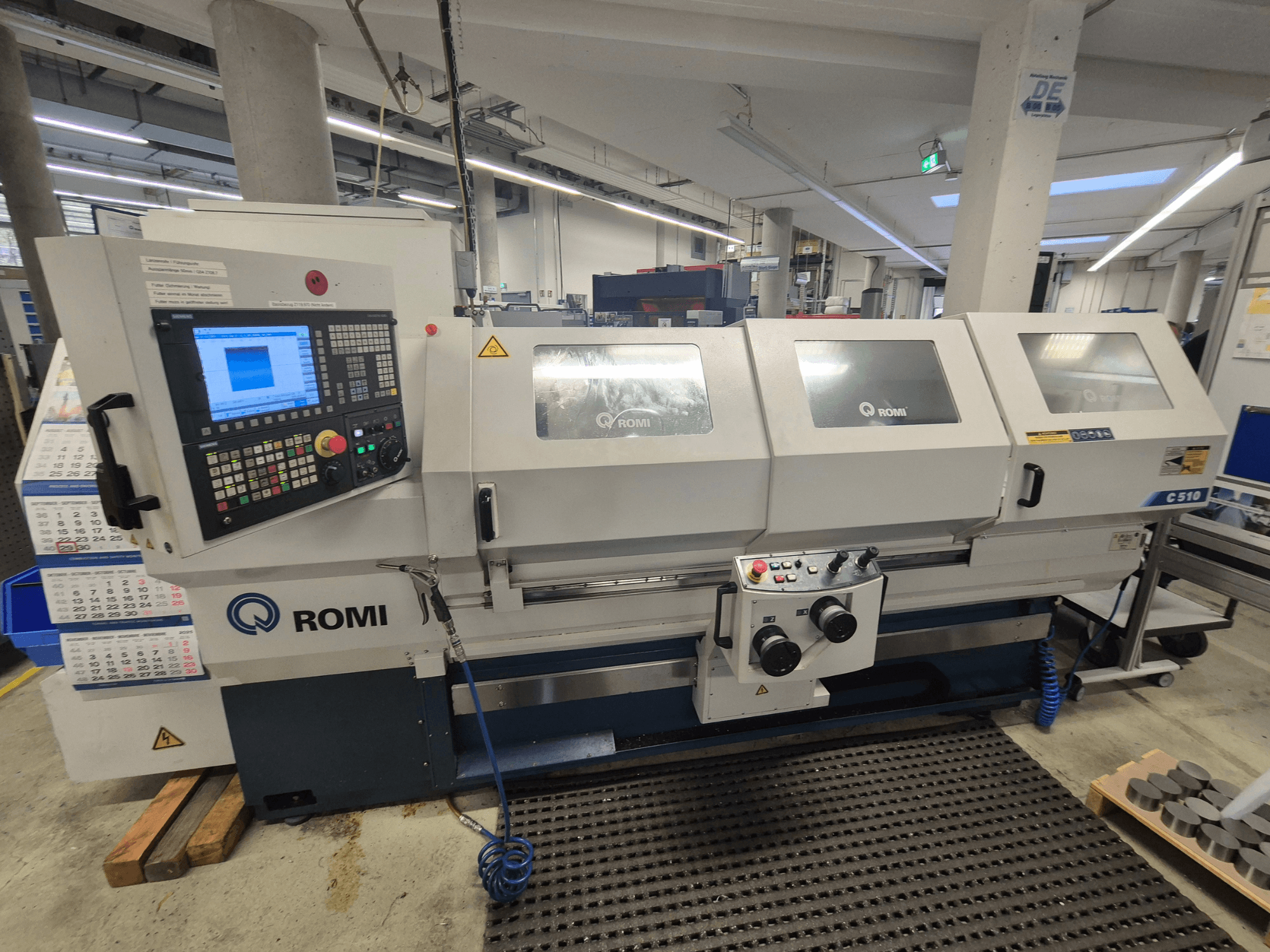 Tour Romi C510 vu de face, doté d'un panneau de commande numérique et de trois capots de protection. Inclut des étiquettes d'avertissement de sécurité.