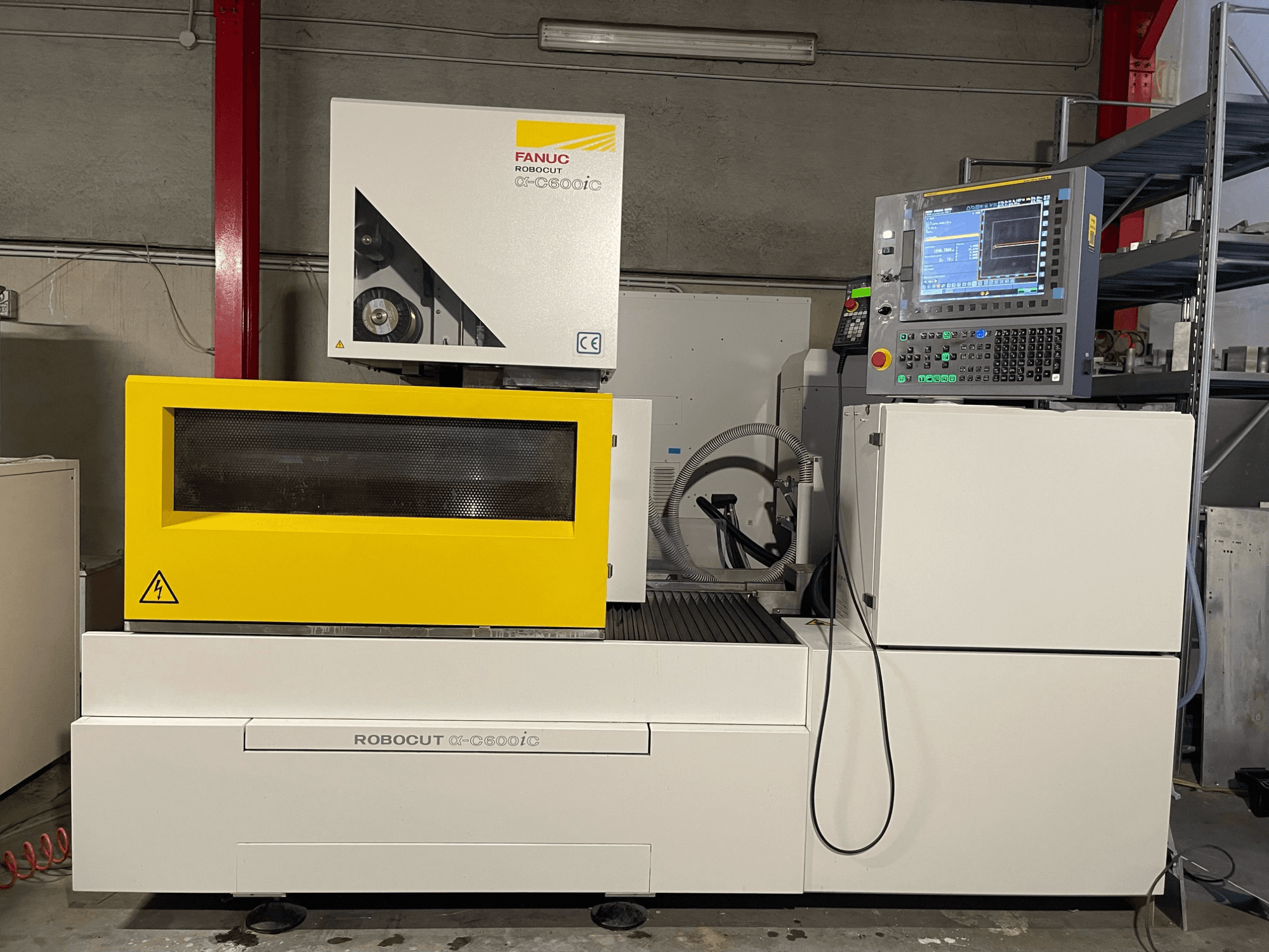 FANUC Robocut α-C600iC, vue latérale de la machine CNC avec couvercle de sécurité jaune et panneau de commande, montrant la capacité de coupe de précision.