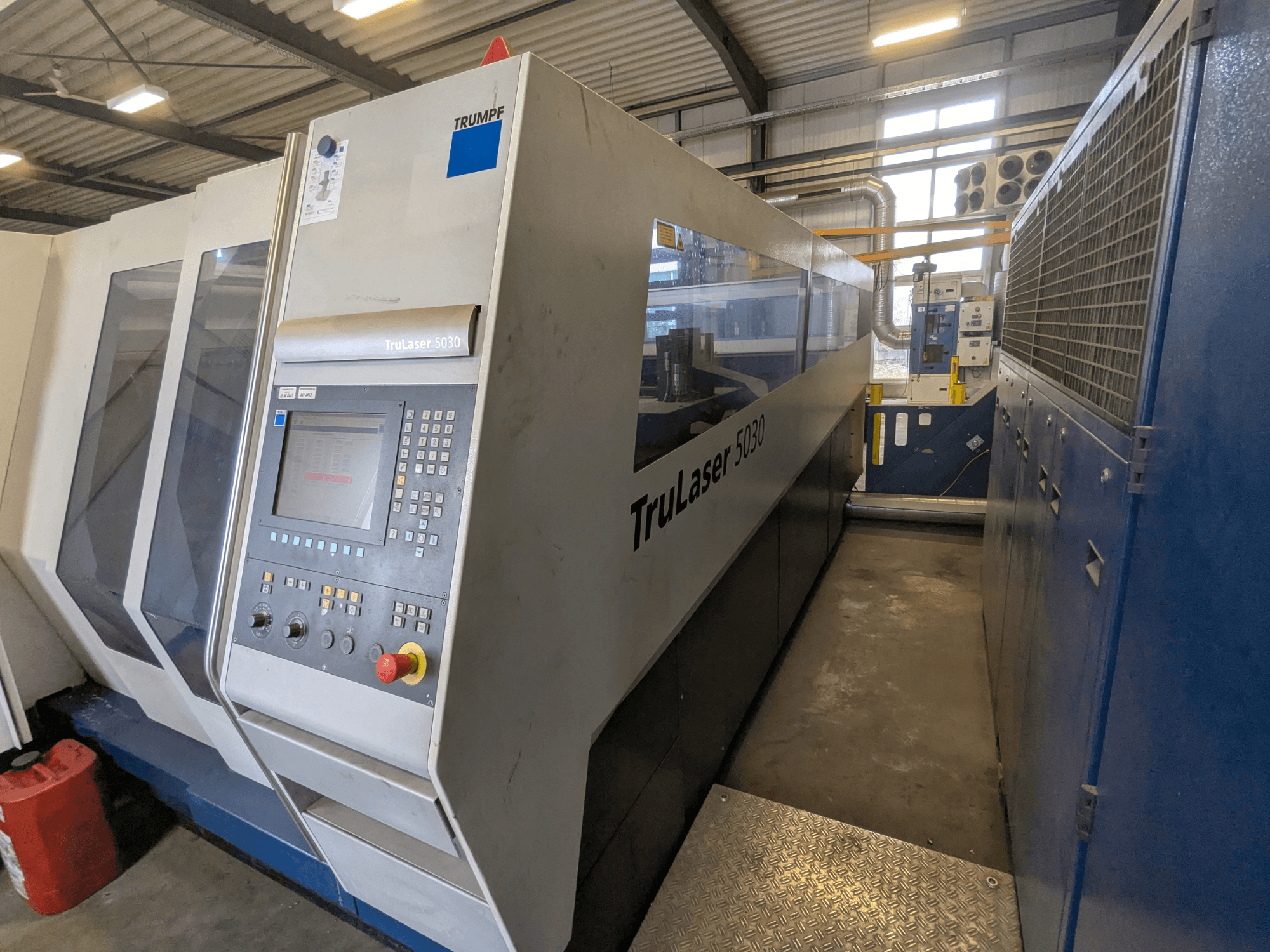 Machine de découpe laser TruLaser 5030 de TRUMPF, vue de face montrant le panneau de commande et le design épuré, dans un environnement industriel.