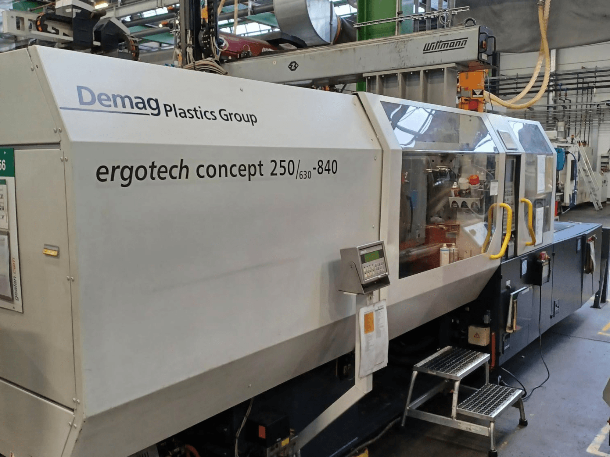 Machine de moulage par injection Demag ergotech concept 250/630-840, vue de face, montrant les commandes numériques et les couvercles de sécurité transparents.
