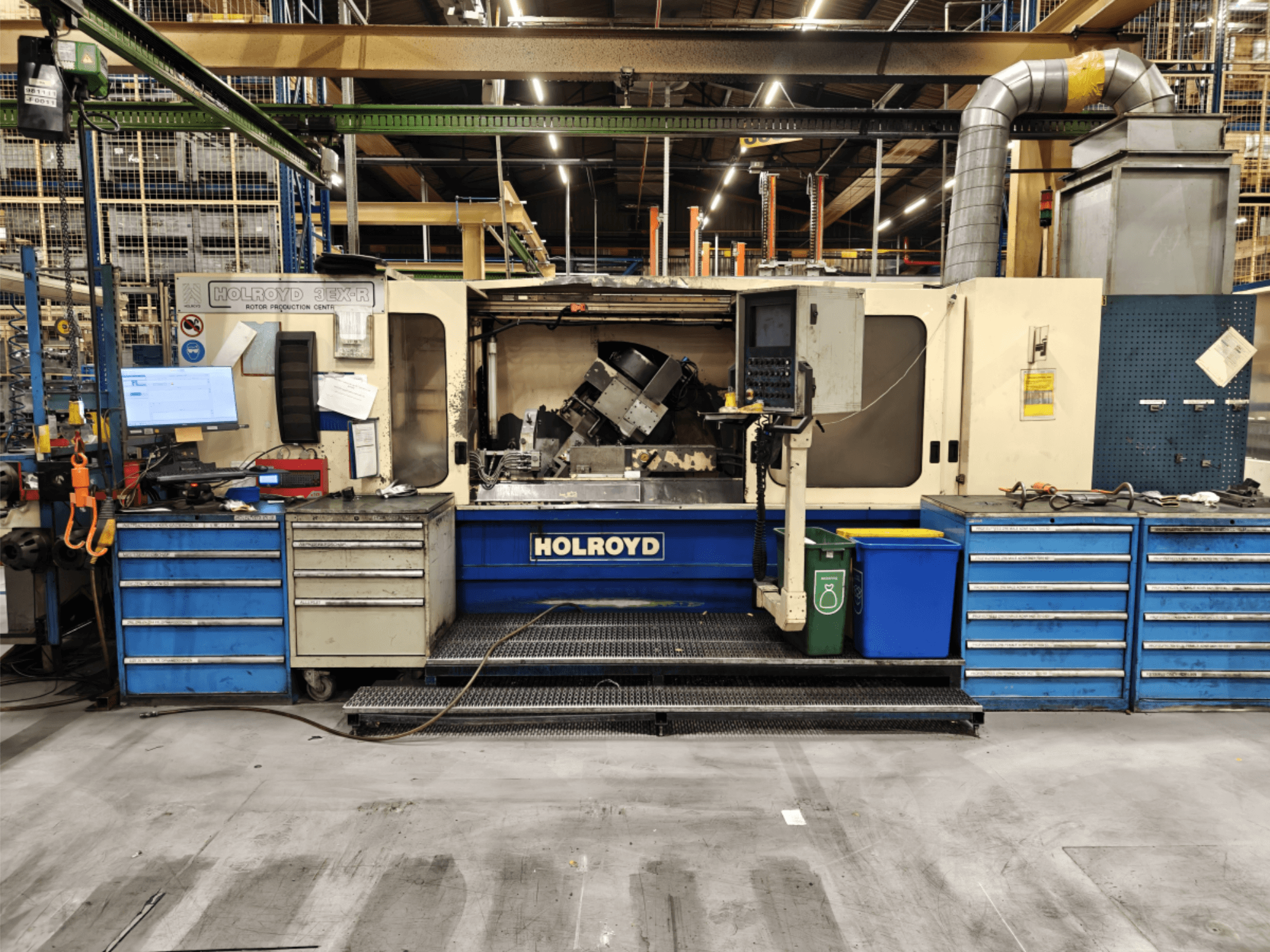 Machine-outil Holroyd 3EX-R dans un atelier, vue de face, montrant le panneau de commande, le stockage des outils et la zone de travail à l'intérieur.