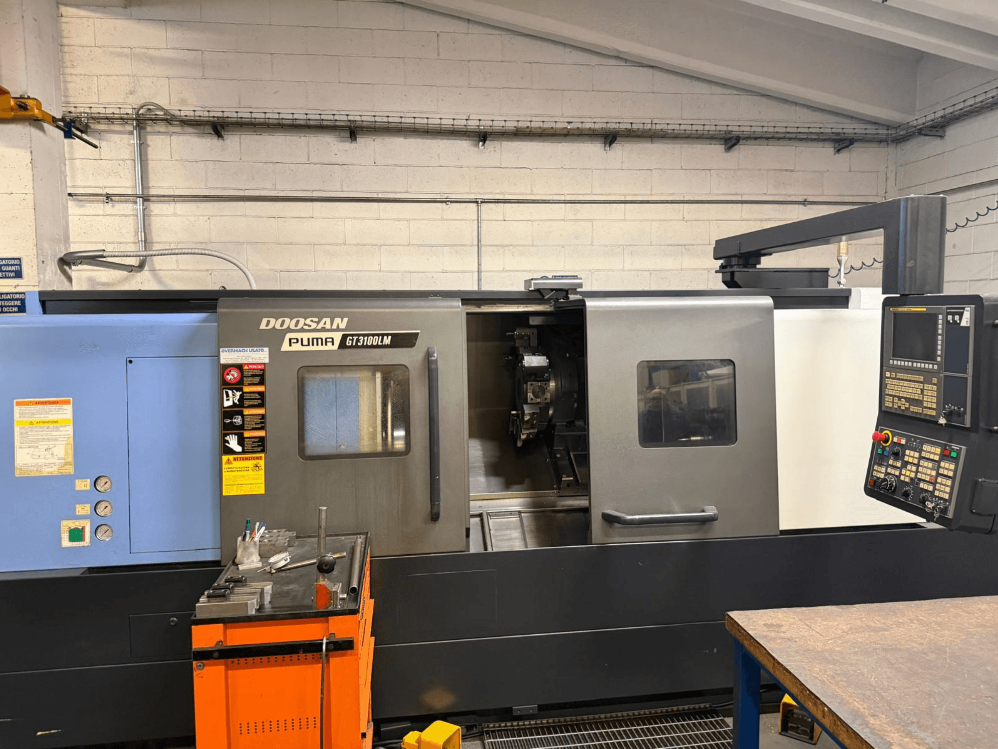 Vue avant du tour horizontal DOOSAN PUMA GT3100LM, montrant le panneau de commande et la zone de travail avec les outils.