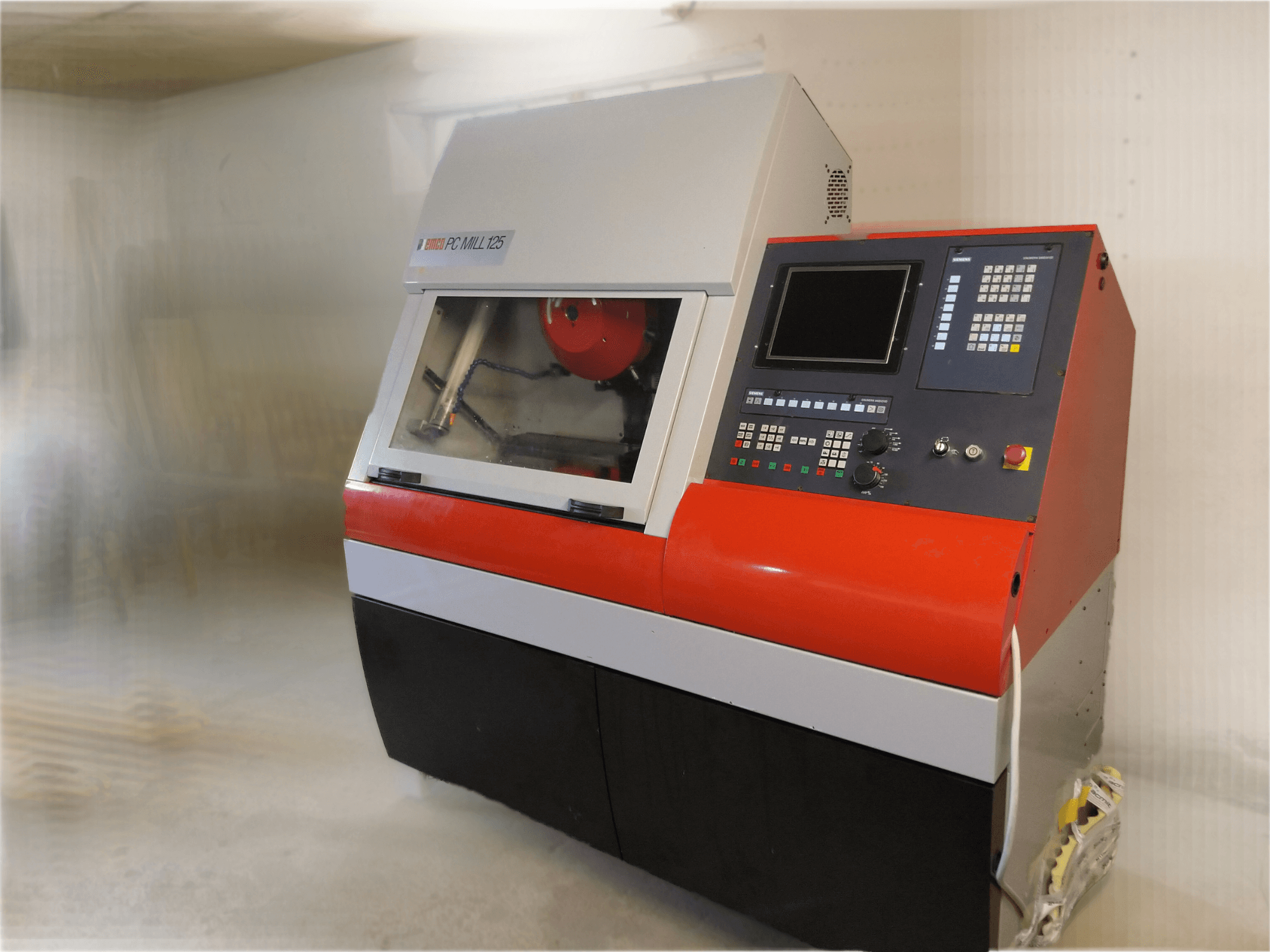 Centre d'usinage vertical EMCO PC MILL 125, vue de face avec panneau de commande et zone d'usinage visible.