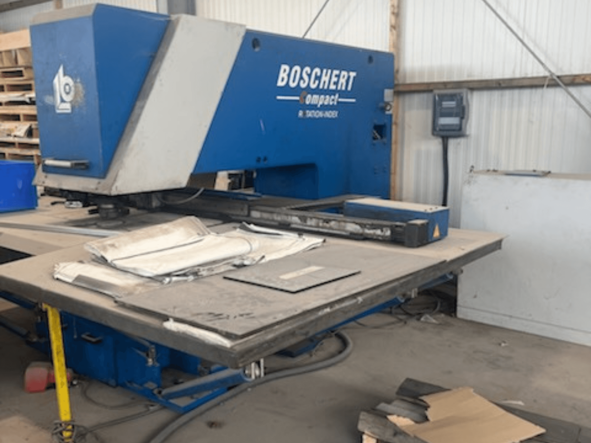 Poinçonneuse CNC BOSCHERT COMPACT 1000 dans un atelier, vue de face avec des tôles posées sur la table.