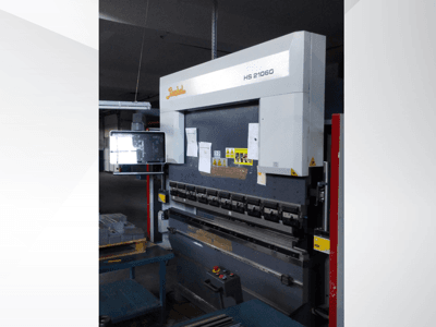 Presse plieuse Beyeler HS 21060, vue de face, montrant des commandes, un écran d'affichage et des étiquettes d'avertissement dans un atelier.