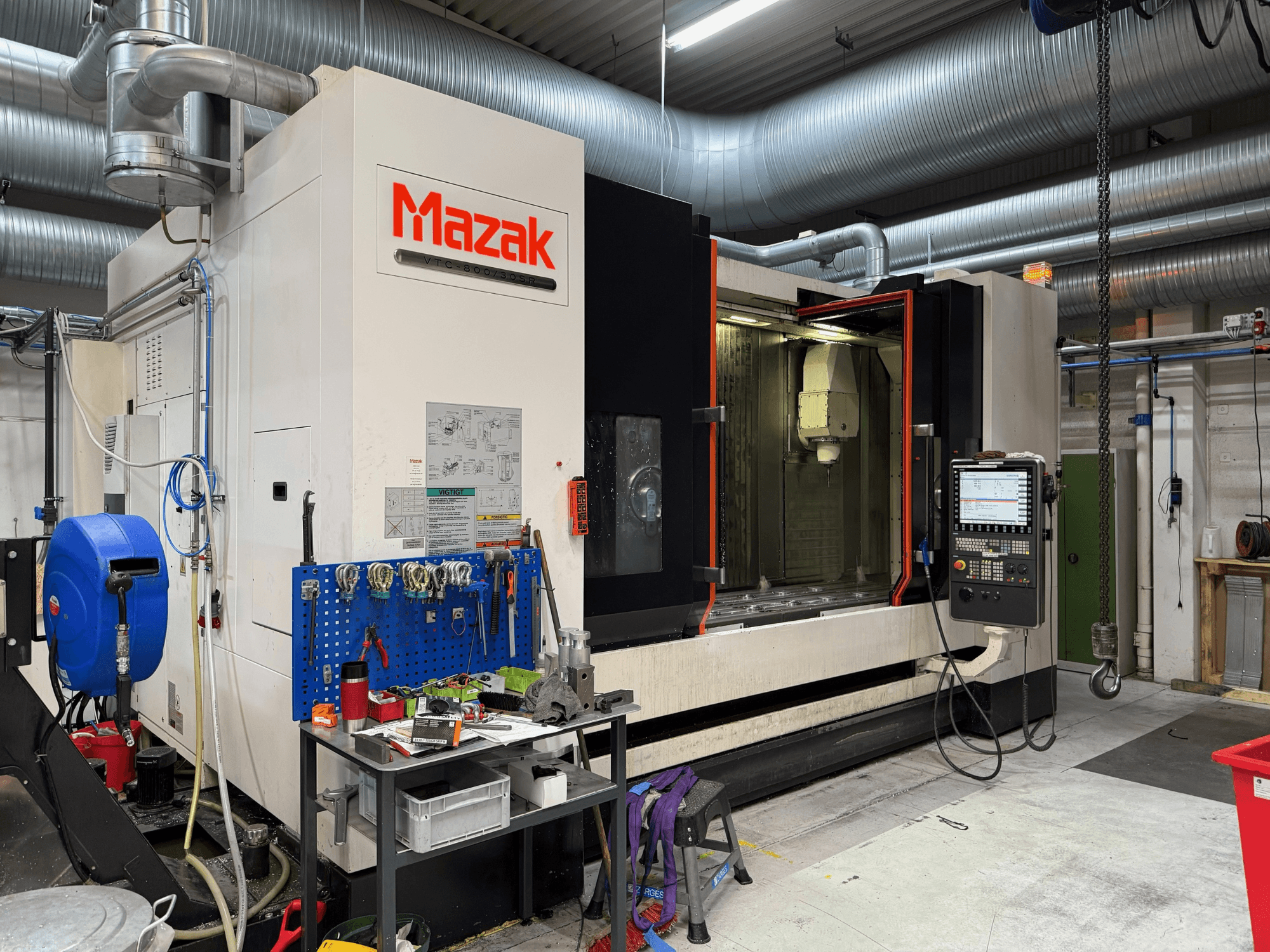 Machine CNC Mazak vue de face, présentant les commandes, les outils et l'espace de travail dans un environnement d'usinage.