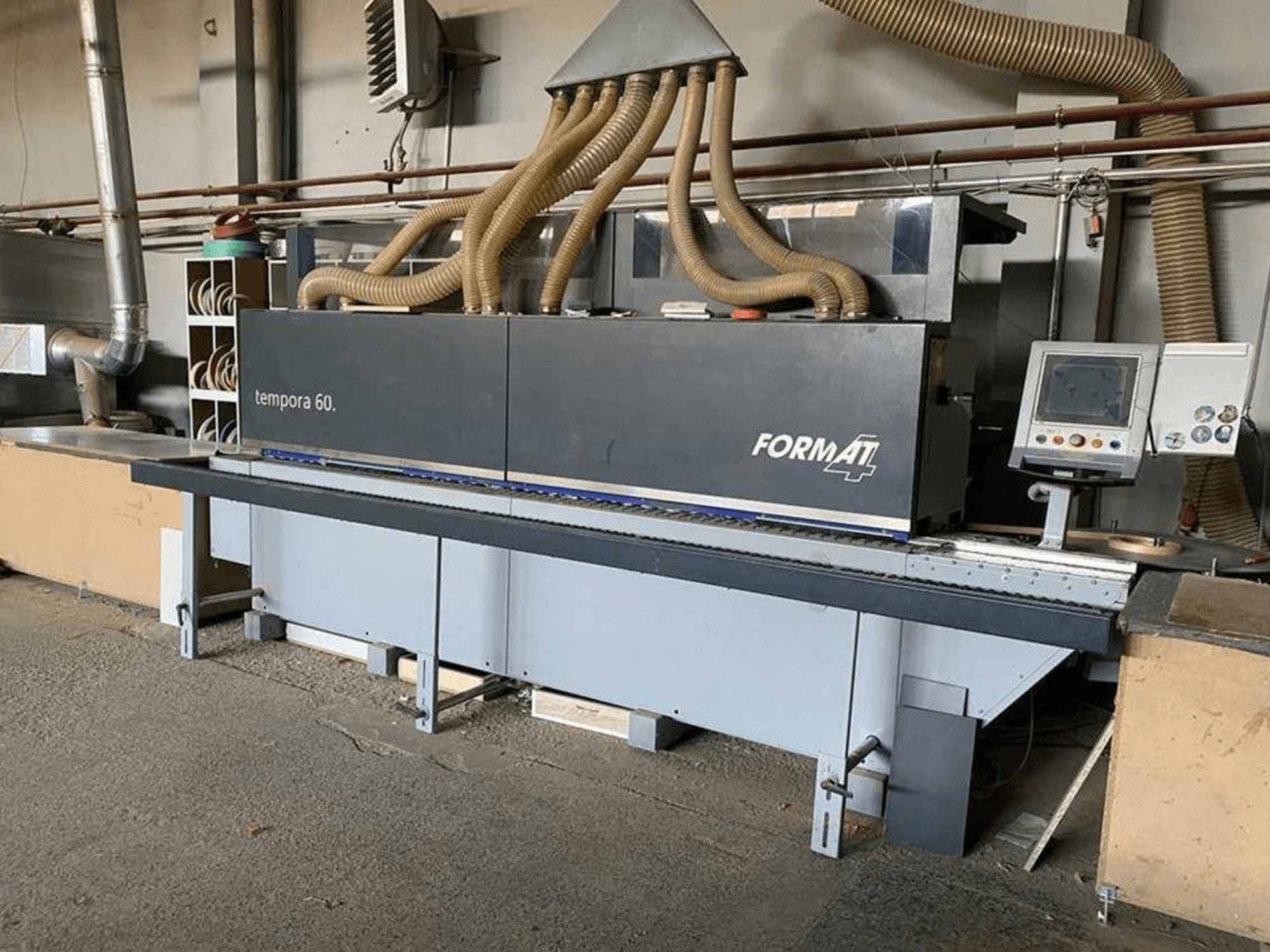 FORMAT4 Tempora 60 plaqueuse de chants en vue latérale, avec plusieurs tuyaux et un panneau de commande avec boutons et écran.