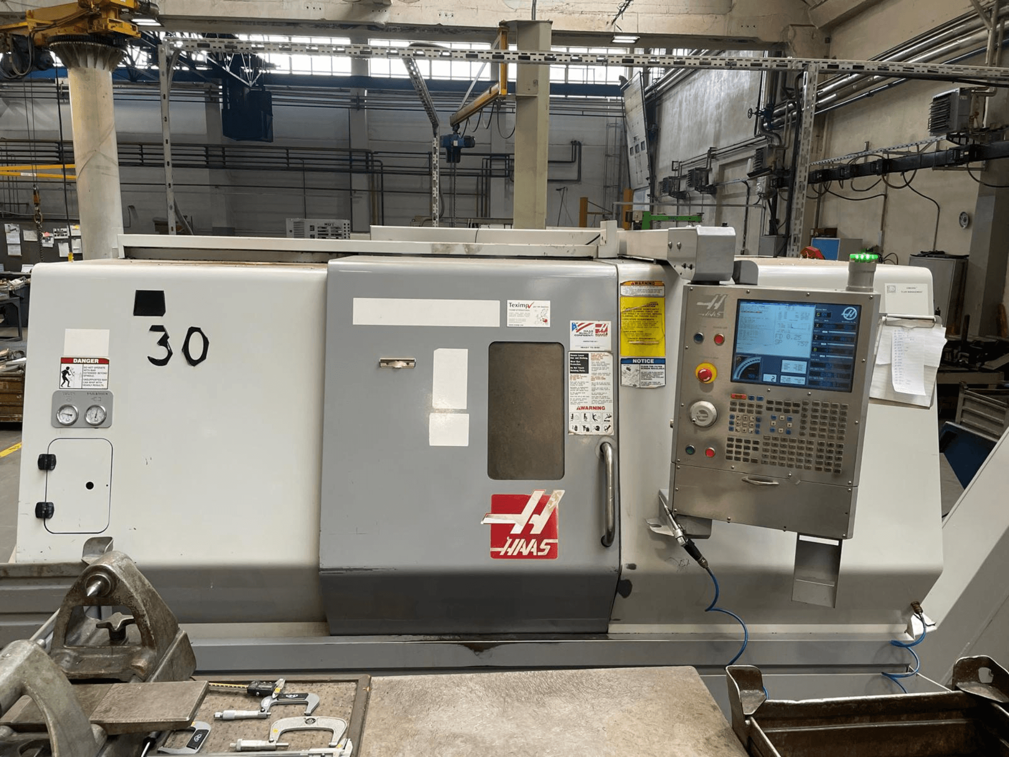 Vue de face du tour horizontal Haas SL-30THE, avec son panneau de commande numérique, ses étiquettes de sécurité et son numéro de modèle 30.