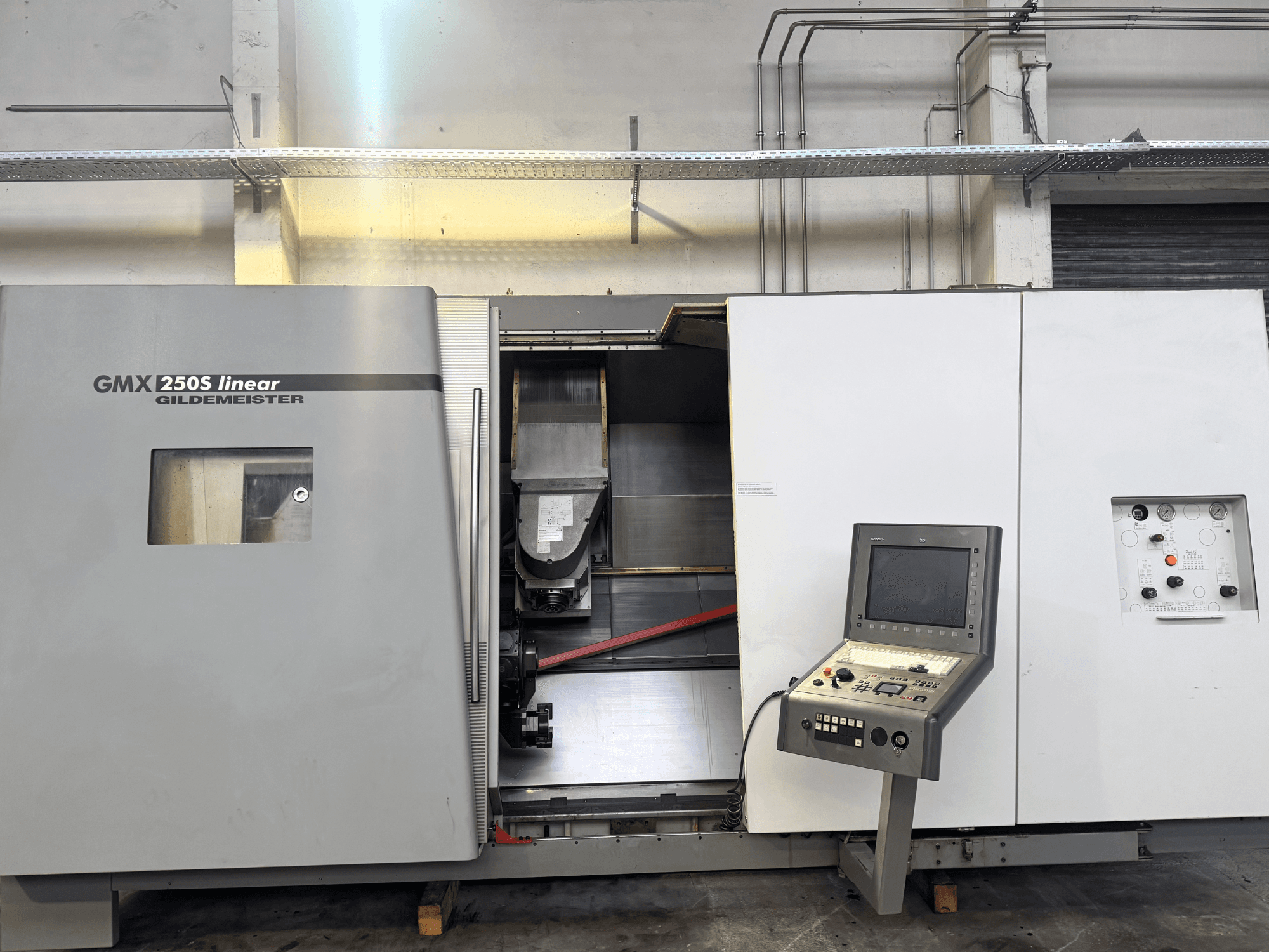 Machine CNC linéaire Gildemeister GMX 250S, vue de face, présentant le panneau de commande et la zone de travail ouverte.