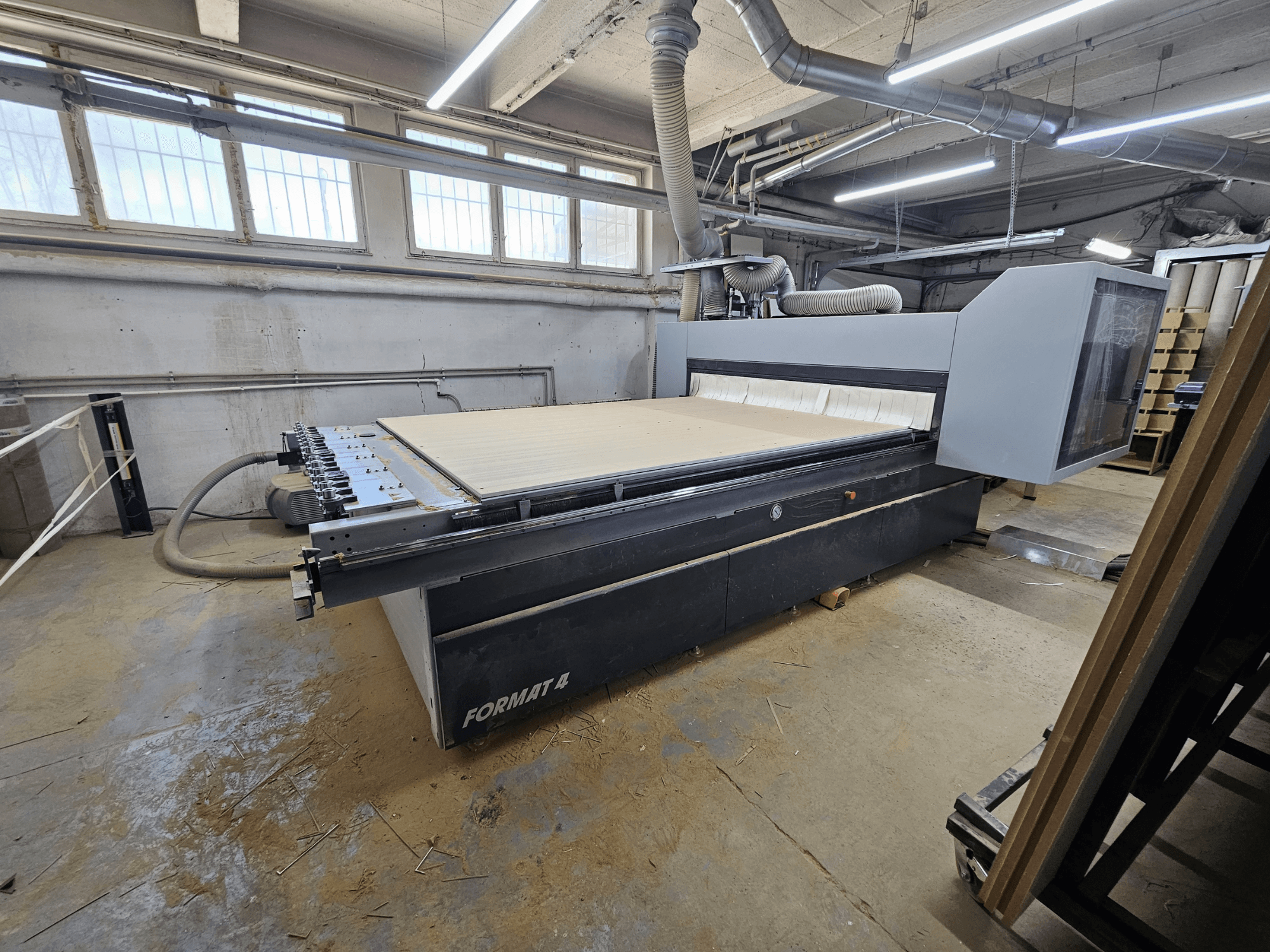 Toupie CNC FORMAT4 Profit H80 21.31, vue latérale montrant la grande table de travail et le panneau de commande dans un atelier.