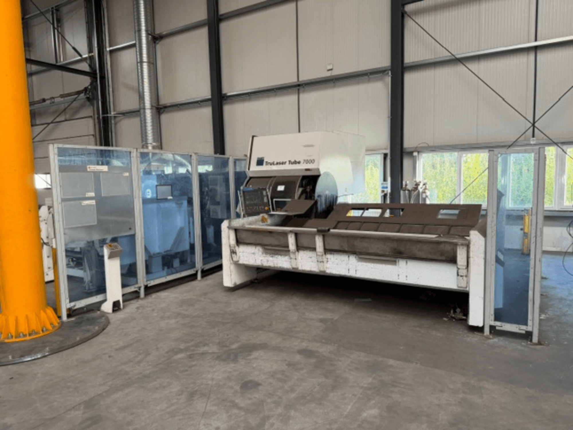 TruLaser Tube 7000 de TRUMPF : vue de face d'une machine de découpe de tubes dans un environnement industriel bien éclairé, avec les commandes de fonctionnement bien visibles.