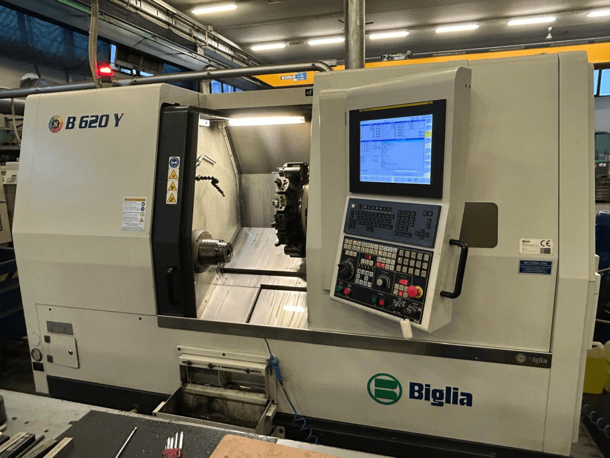 Tour CNC Biglia B 620 Y dans un atelier, vue de face, montrant le panneau de commande avec affichage numérique et les composants d'usinage.