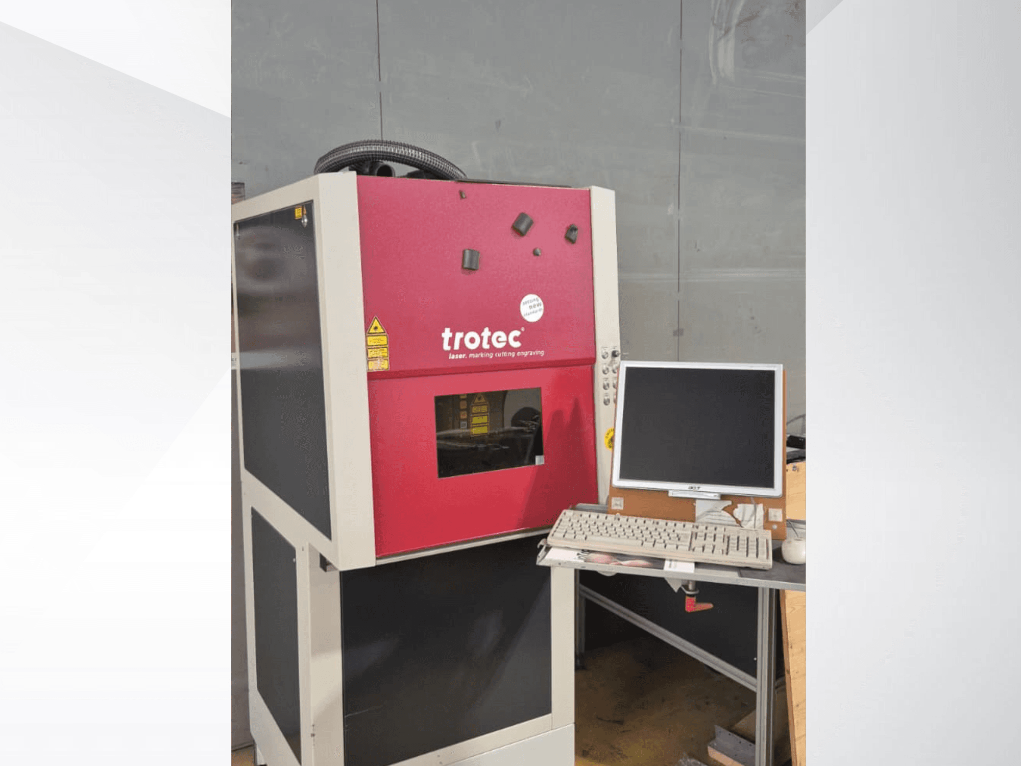 Station de travail laser Trotec rouge, vue de face, équipée d'un écran et d'un clavier.