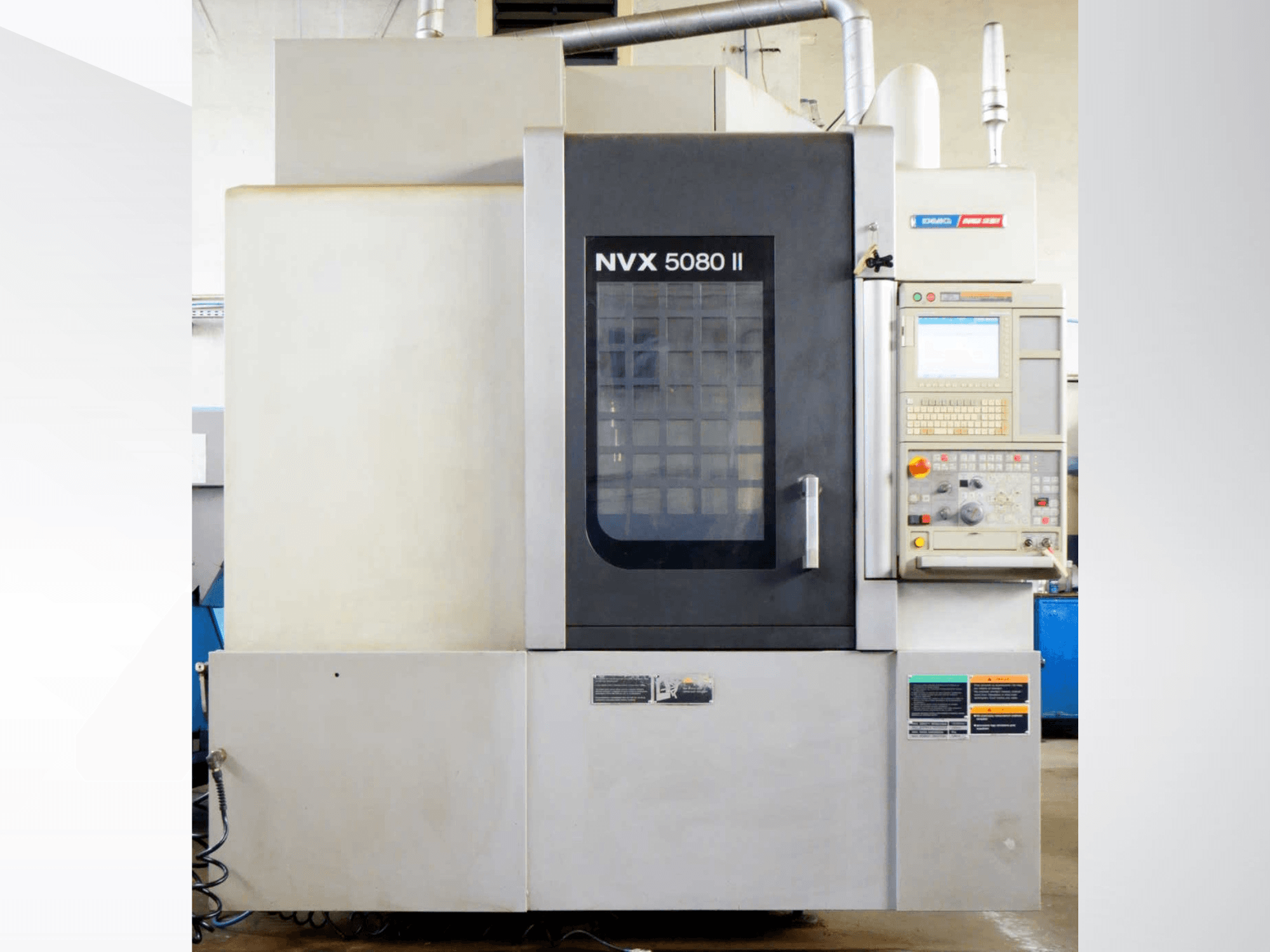 Centre d'usinage vertical DMG Mori Seiki NVX 5080 II, vue de face, avec panneau de commande et porte à grille.