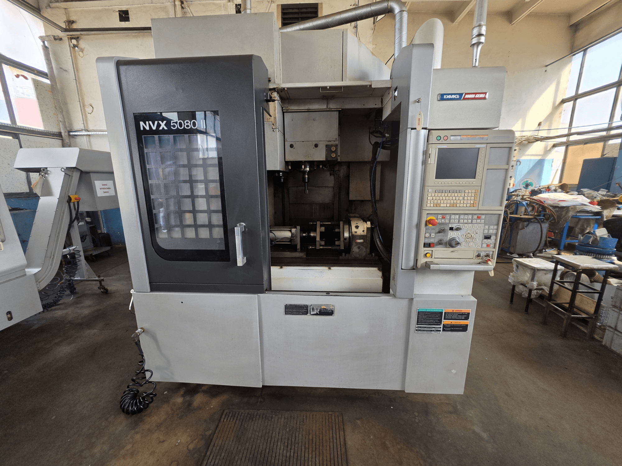 Vue de face du centre d'usinage vertical DMG Mori Seiki NVX 5080 II/40, avec son panneau de commande et sa vitre permettant de voir la zone d'usinage.