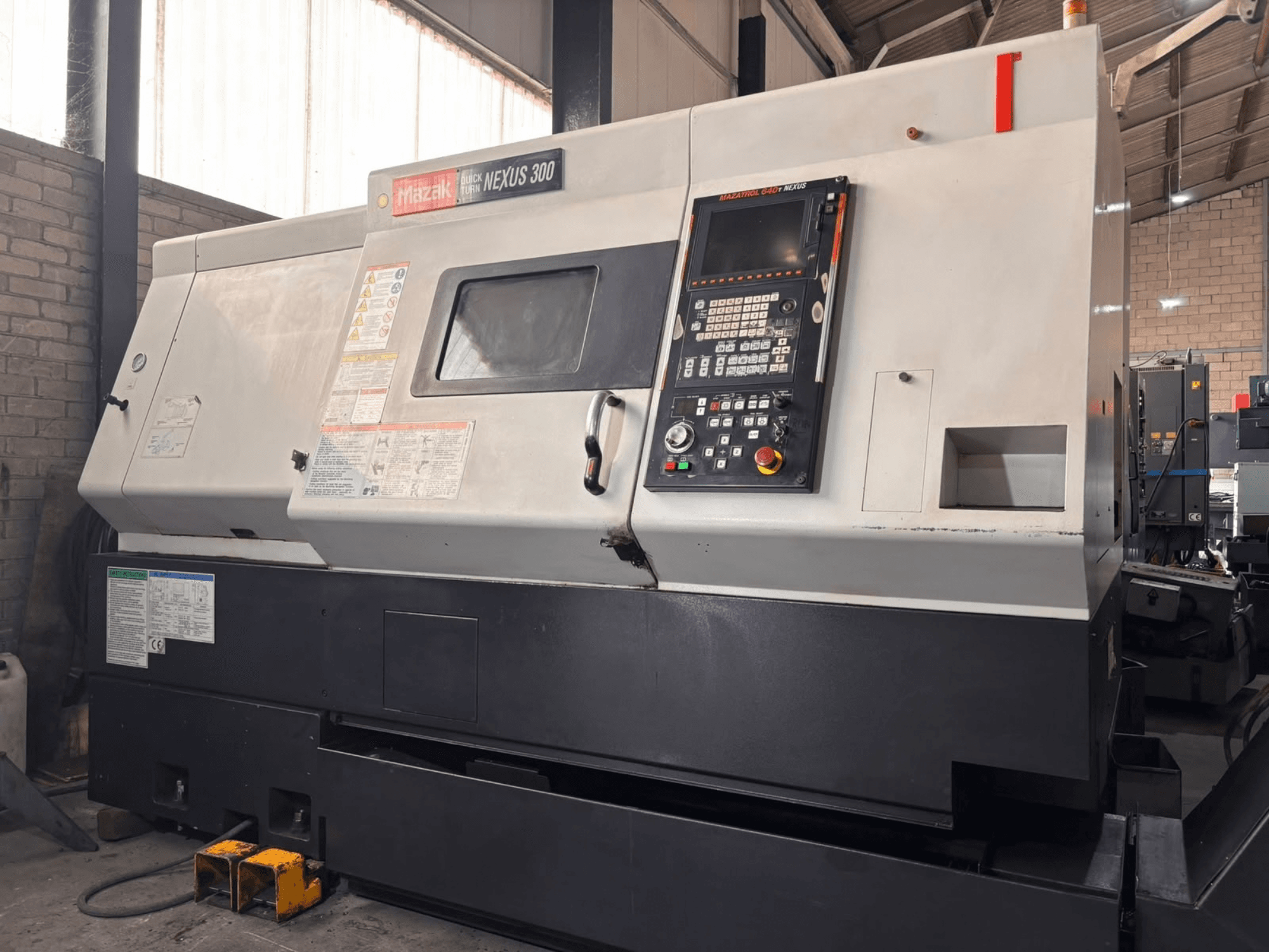Tour horizontal Mazak QT NEXUS 300, vue de profil montrant le panneau de commande et les voyants de fonctionnement dans un atelier.