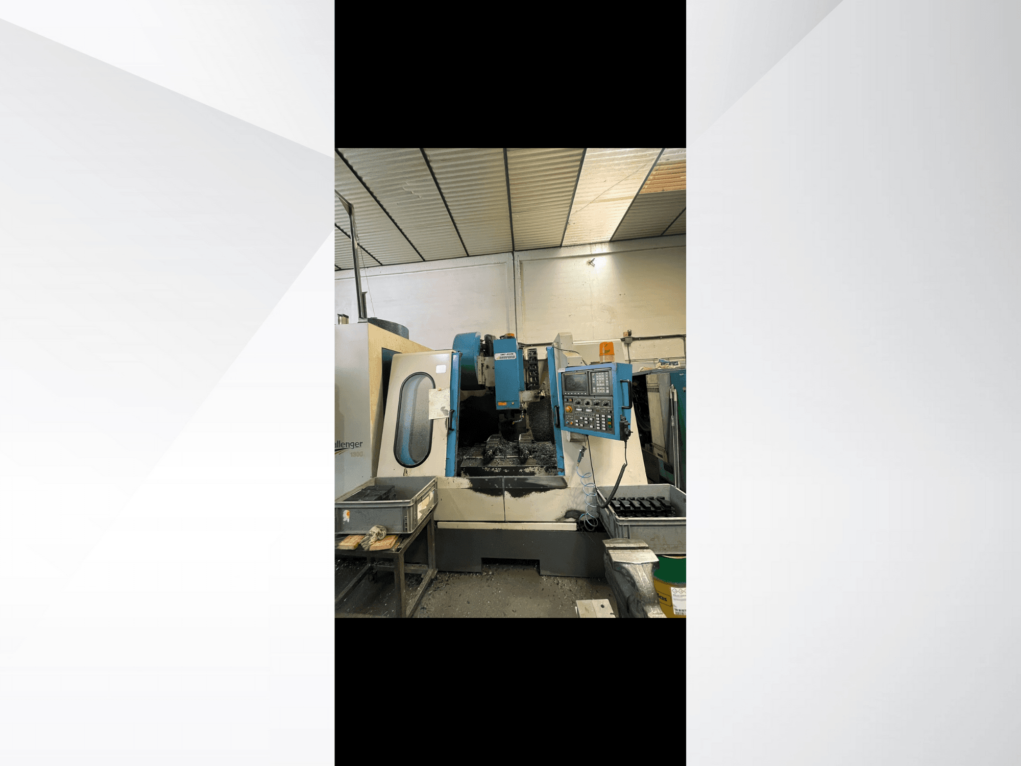 Machine CNC, modèle Challenger 1500, vue latérale montrant le panneau de commande et l'espace de travail avec des copeaux de métal.