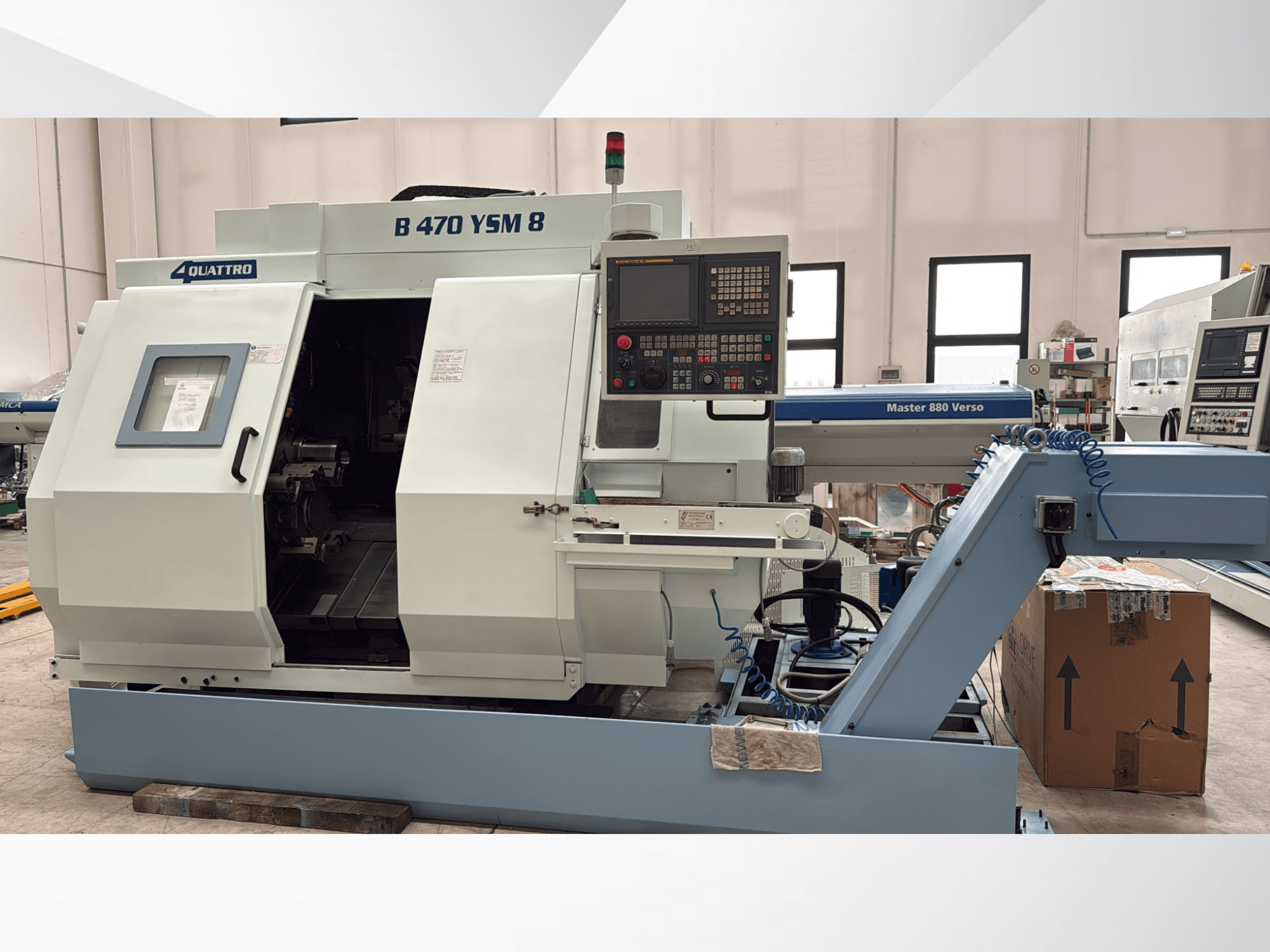 Centre de tournage-fraisage Biglia B470 YSM, vue de face montrant le panneau de commande, la trappe ouverte et l'espace de travail avec les outils à l'intérieur.