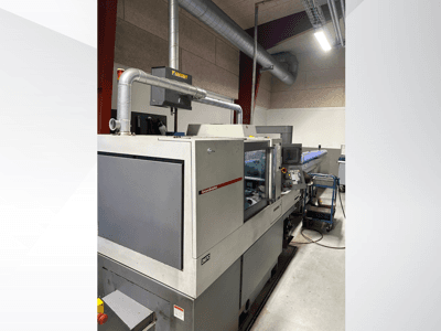 Machines industrielles de la marque MVC, vue de côté avec panneau de commande et conduits visibles, dans un environnement d'usine.