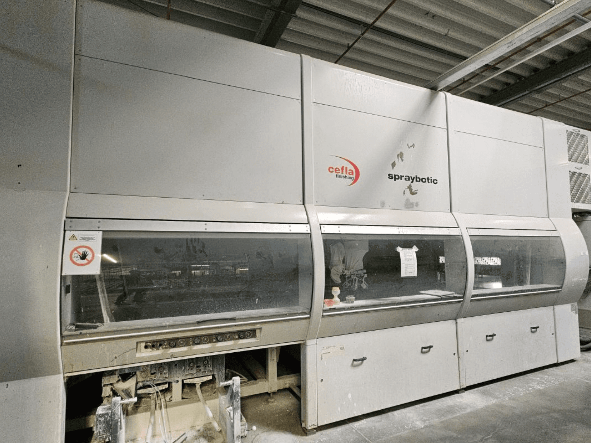 Ligne de production Cefla Spraybotic MD pour le bois, vue de face, présentant le panneau de commande et les fenêtres d'affichage claires.