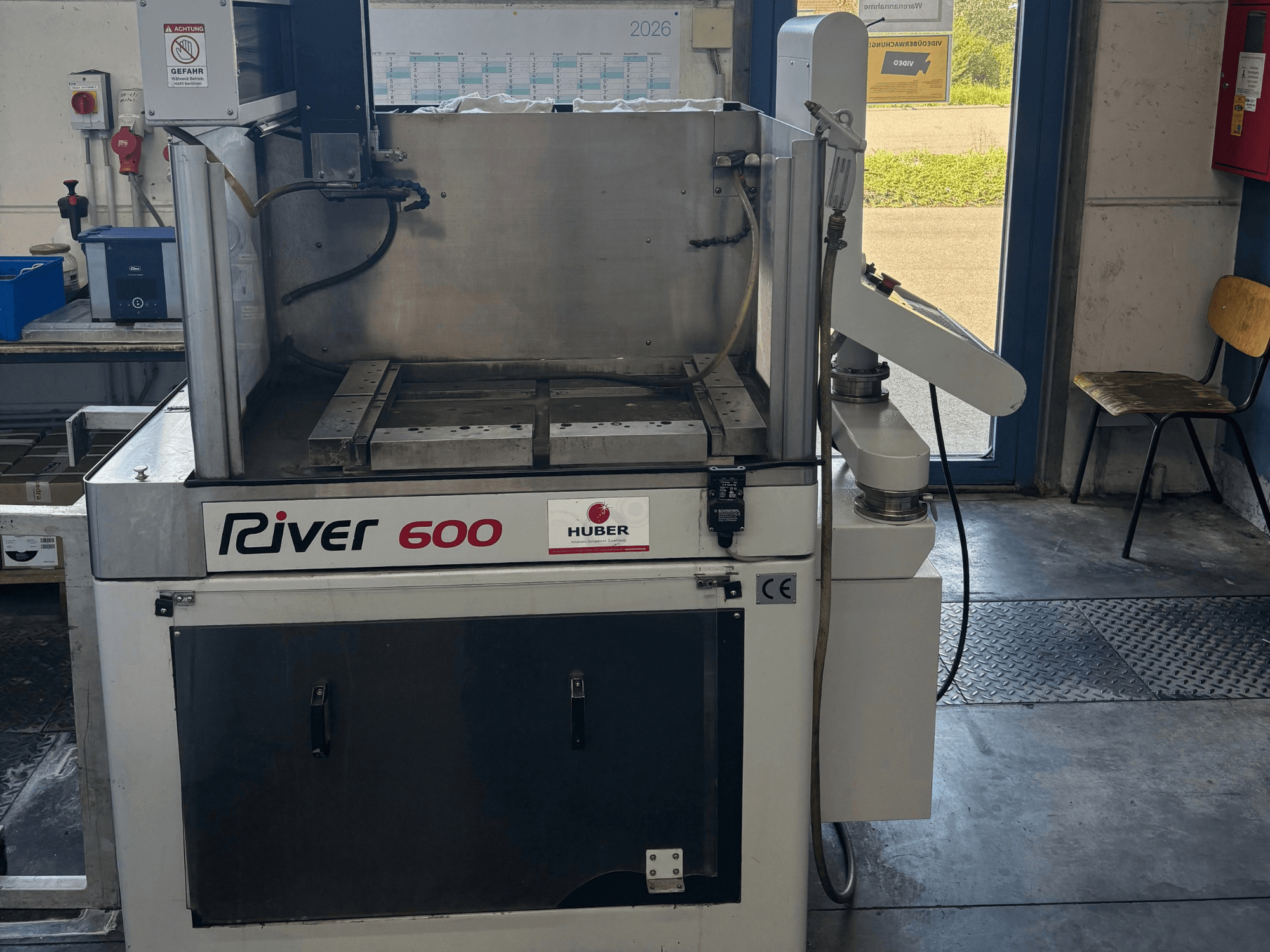 Machine d'électroérosion par enfonçage HUBER River 600 CNC, vue de face, présentant une chambre de travail partiellement ouverte et un panneau de commande.