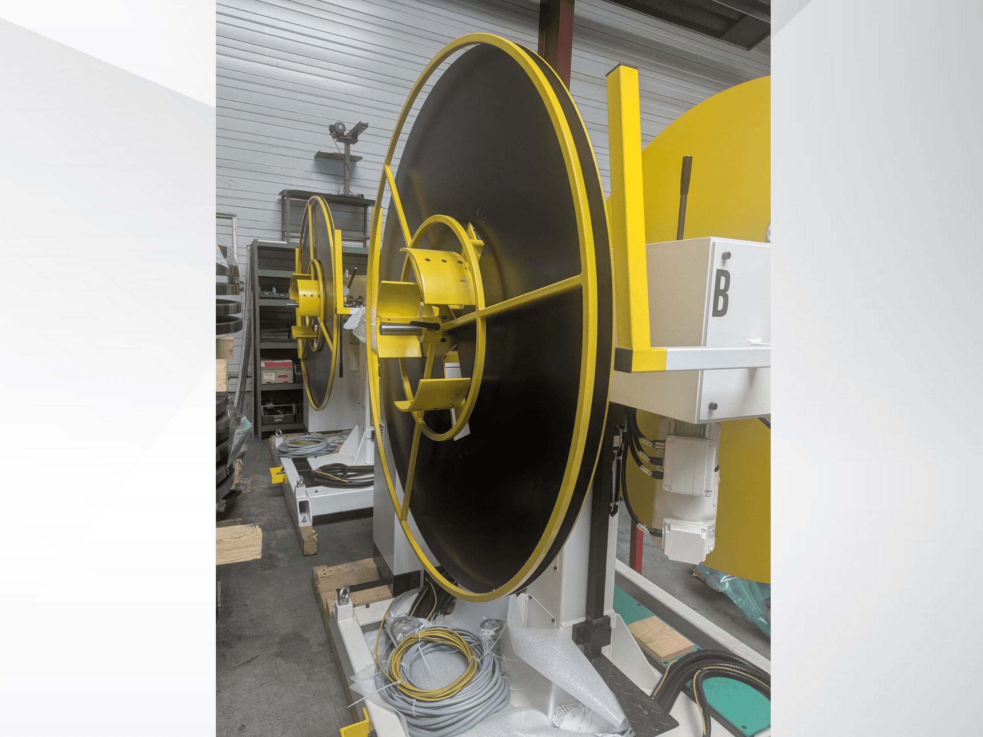 Grande bobine industrielle, modèle XYZ, avec une surface noire et des accents jaunes, vue de côté, avec des connexions électriques.