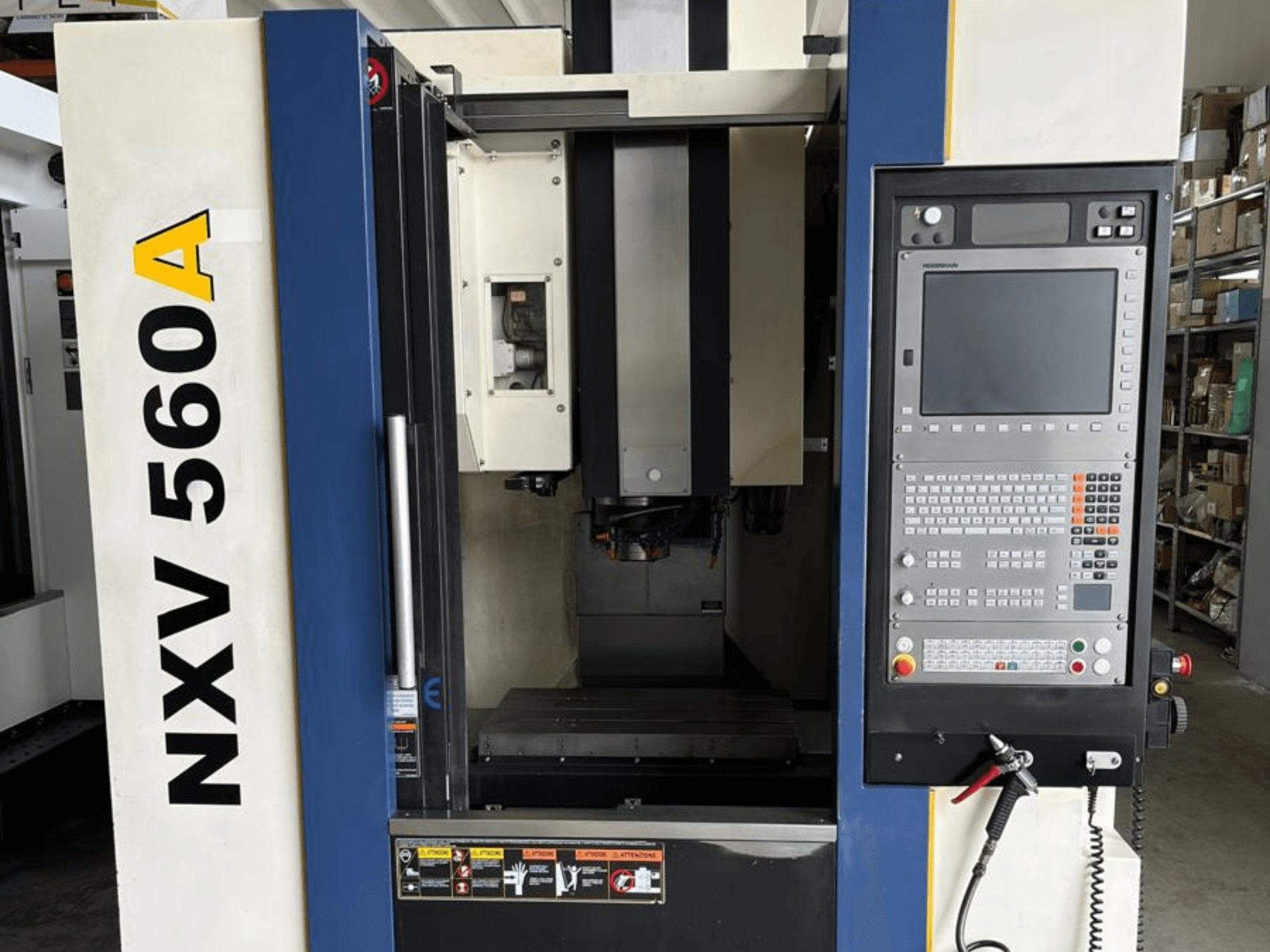 Machine CNC NXV 560A vue de face, dotée d'un panneau de commande avec des boutons et un écran numérique.
