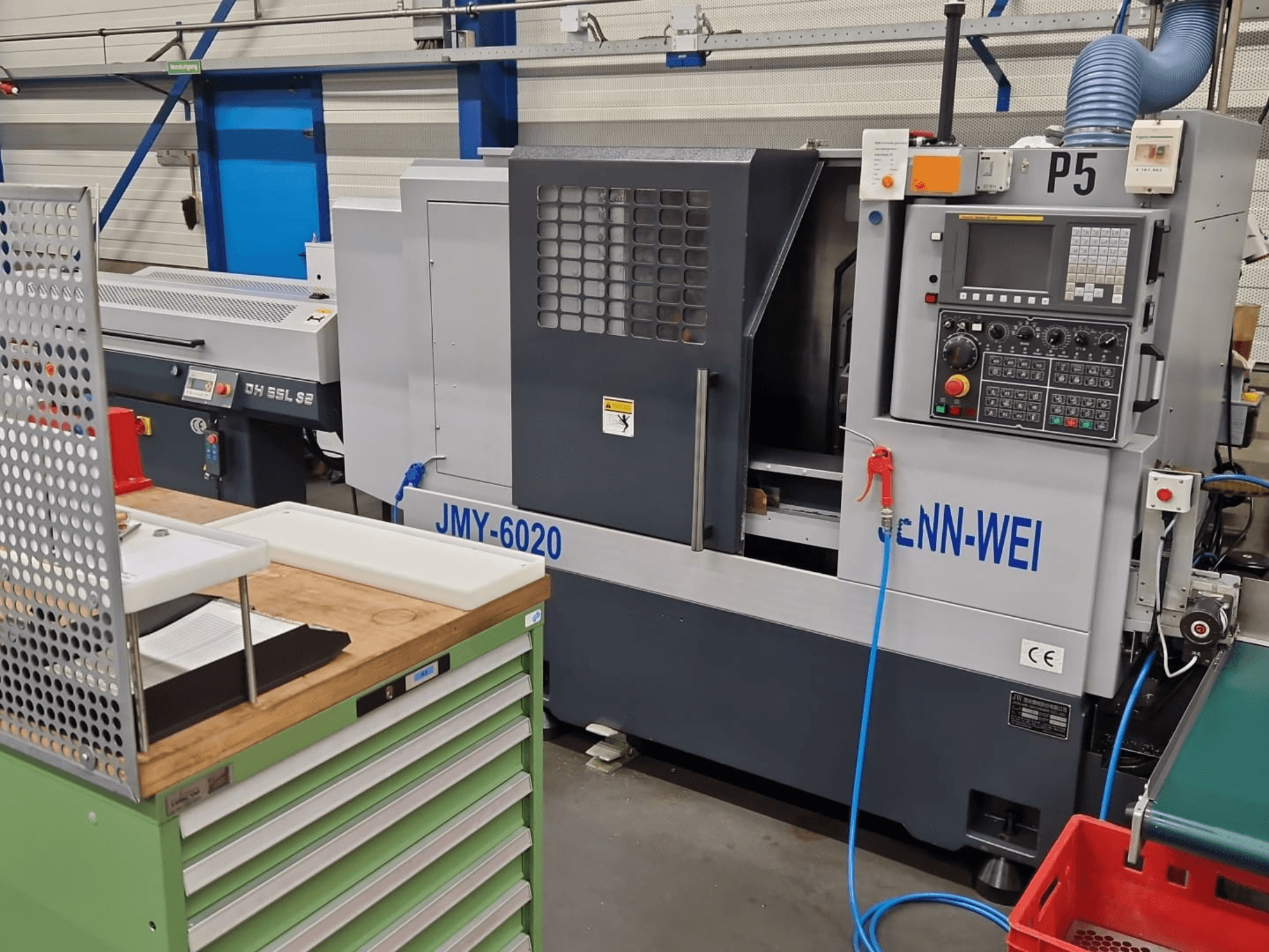 Tour CNC, modèle JMY-6020 de cNN-WEI, vu de face. Panneau de commande, arrêt d'urgence et conduite de liquide de refroidissement.