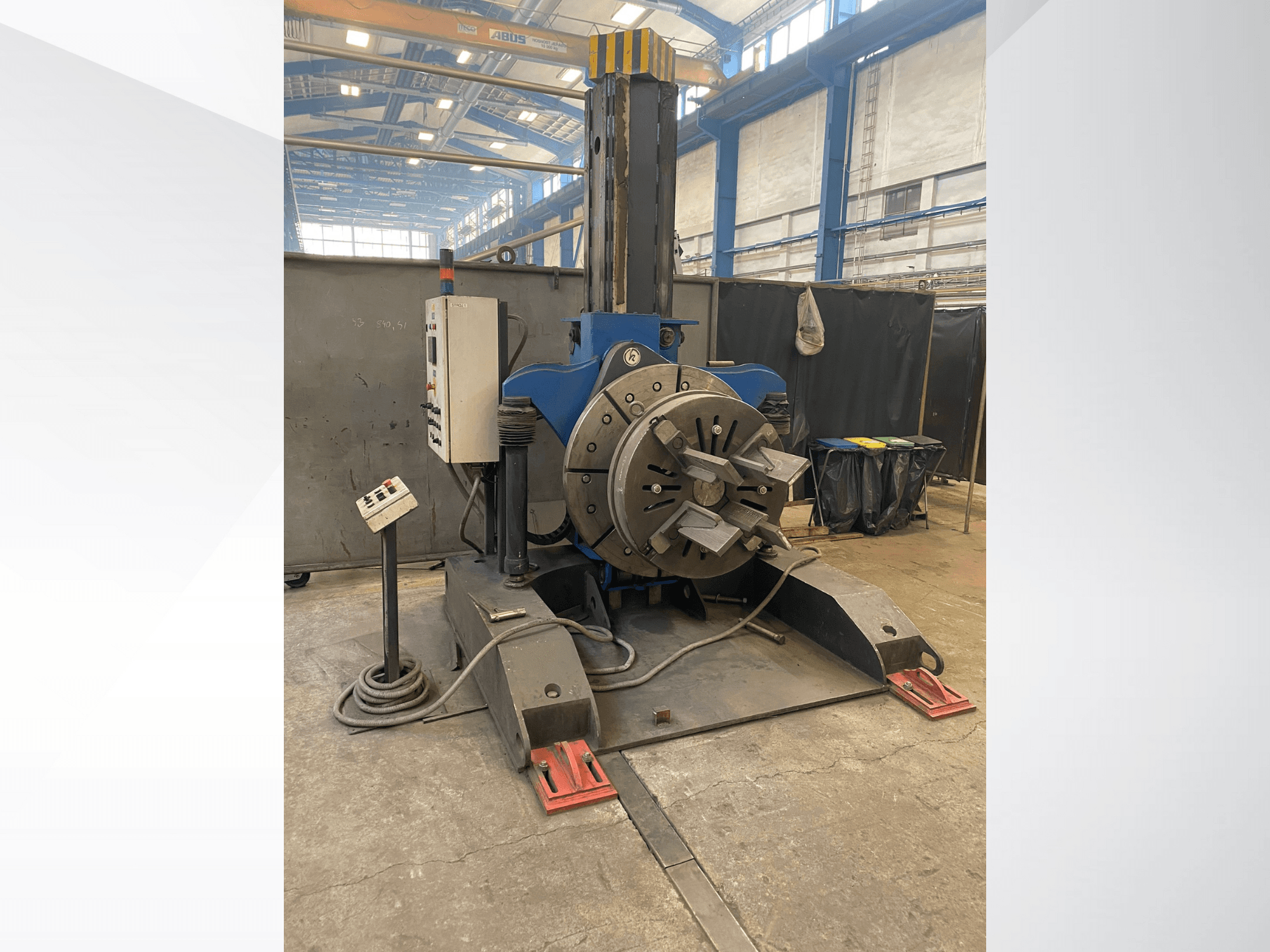 Tour industriel bleu avec tête rotative ronde et panneau de commande, vue latérale, dans un atelier.