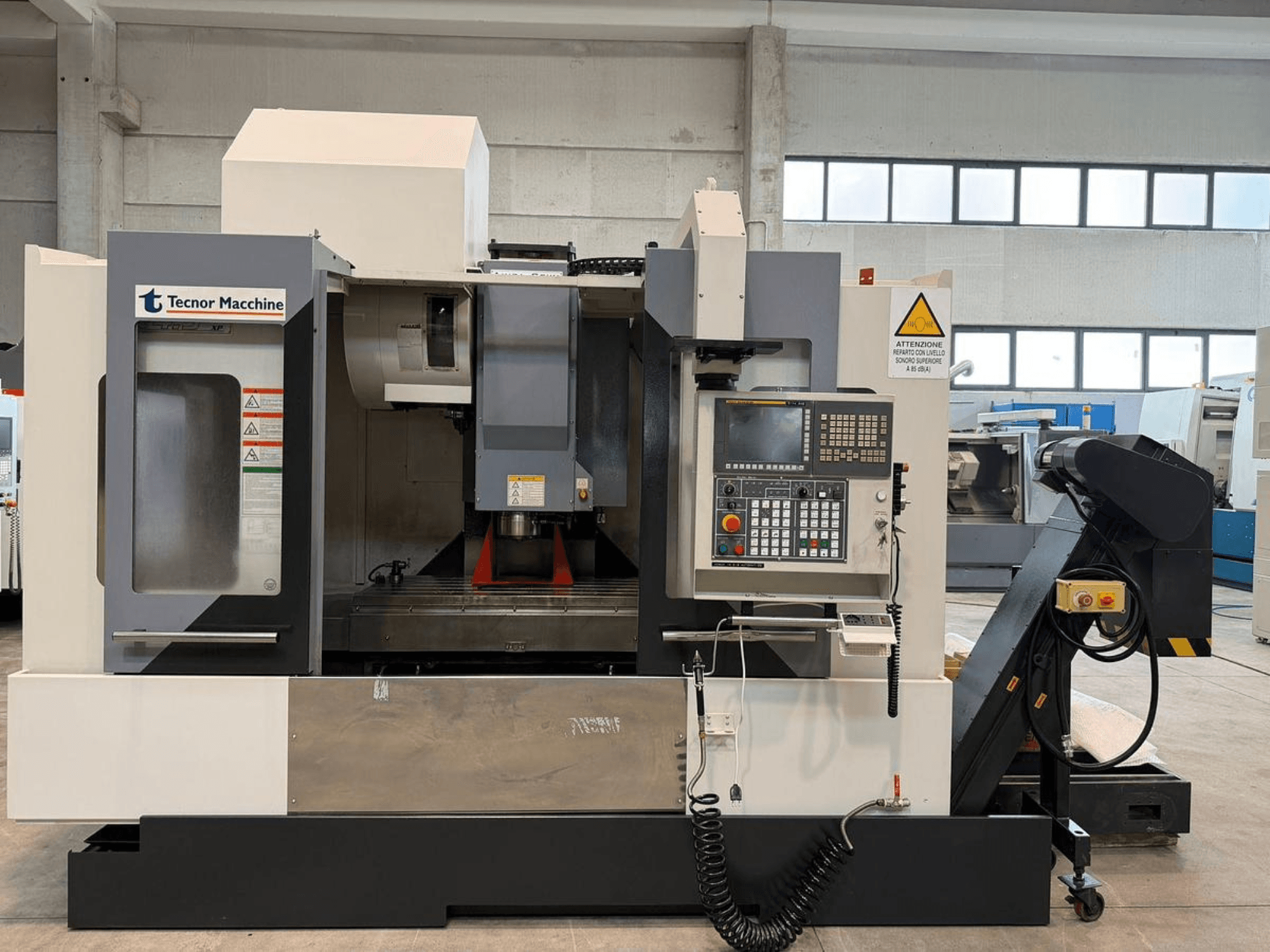 Fraiseuse CNC Tecnor Machine, vue de face, panneau de commande avec boutons, étiquettes d'avertissement et porte-outil.