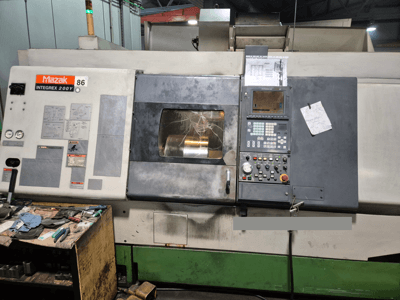 Tour Mazak Integrex 200Y, vue de face, avec panneau de commande et outils sur un banc. Jauges et écran d'affichage visibles.