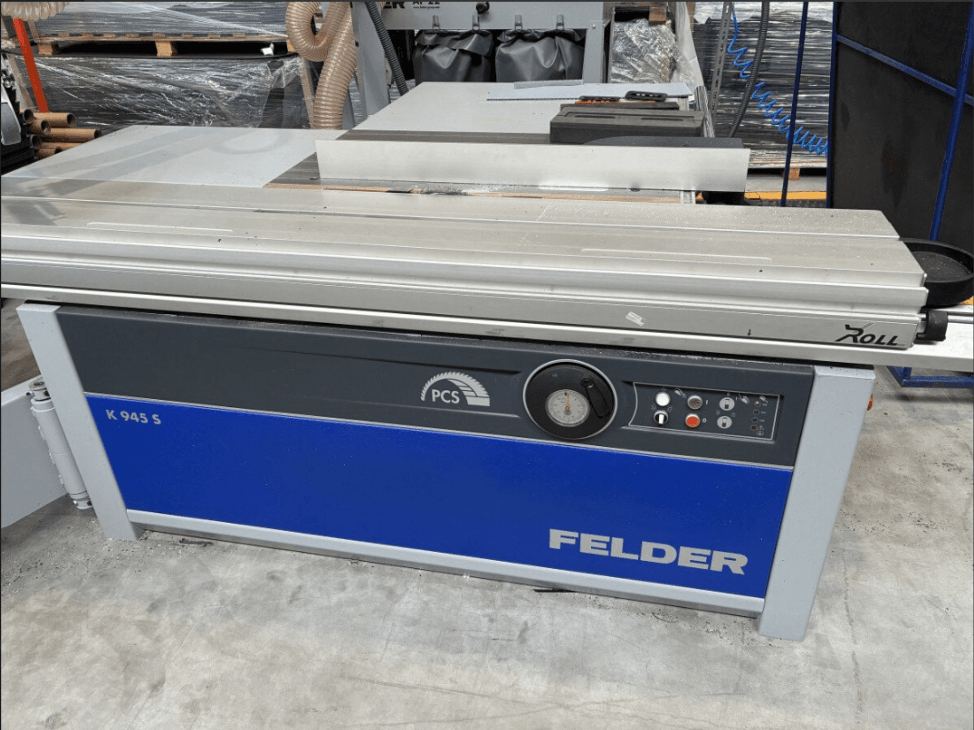 Scie à panneaux FELDER K 945 S, vue de face montrant le panneau de commande, la table et les dispositifs de sécurité, installée dans un atelier.