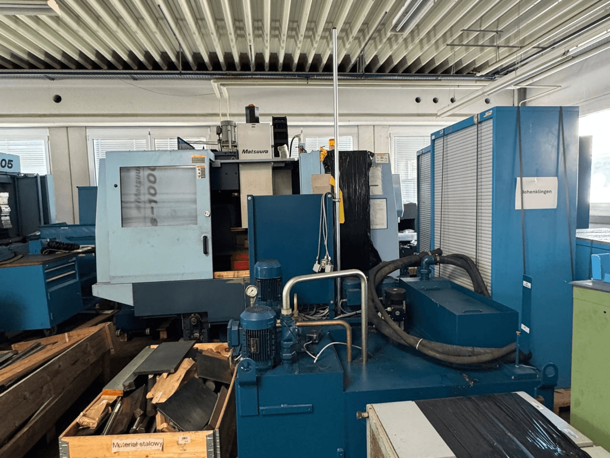 Vue de face du centre d'usinage vertical Matsuura Vplus 1000/40, montrant les commandes, les moteurs et l'environnement de l'atelier qui l'entoure.