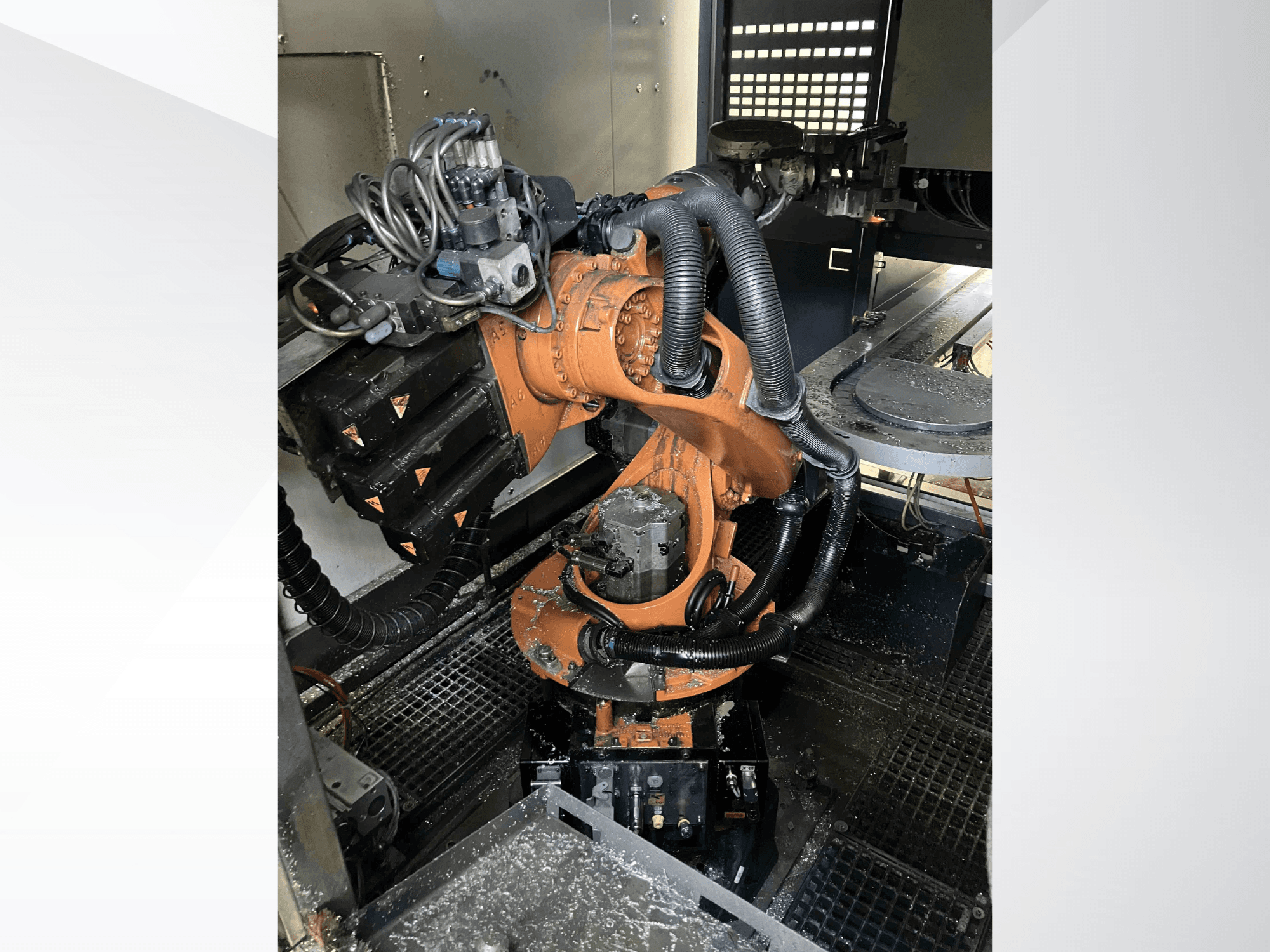Bras robotique KUKA KR 16 vu de dessus, présentant les composants mécaniques et le câblage dans un environnement d'atelier.