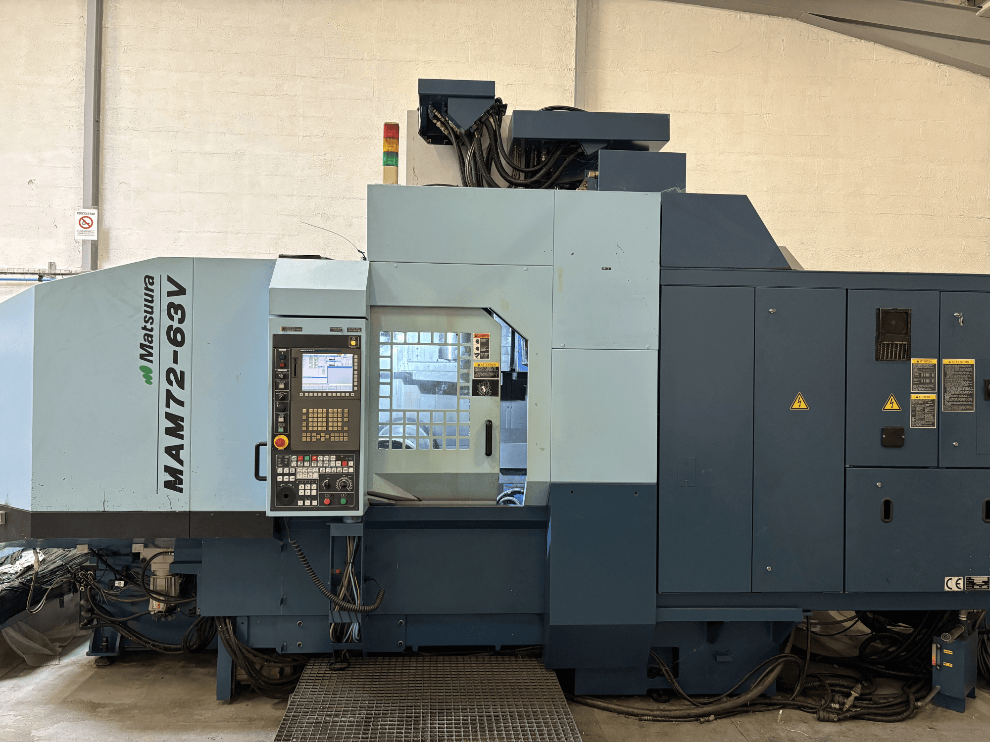 Centre d'usinage vertical Matsuura MAM 72-63 V, vue de face montrant le panneau de commande et les dispositifs de sécurité.