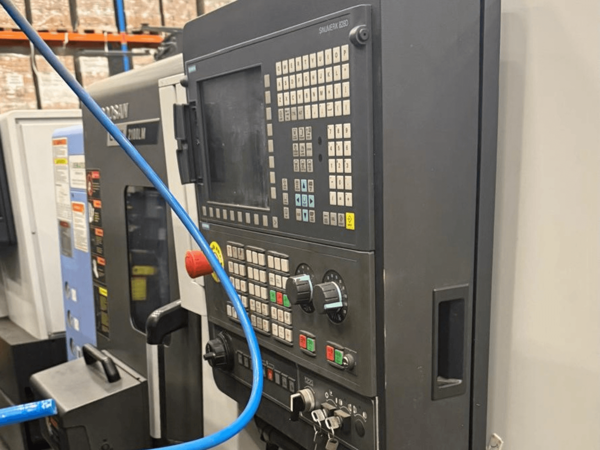 Panneau de commande d'un outil d'usinage, vue de face, comportant des boutons, des molettes et un affichage numérique pour un fonctionnement précis.